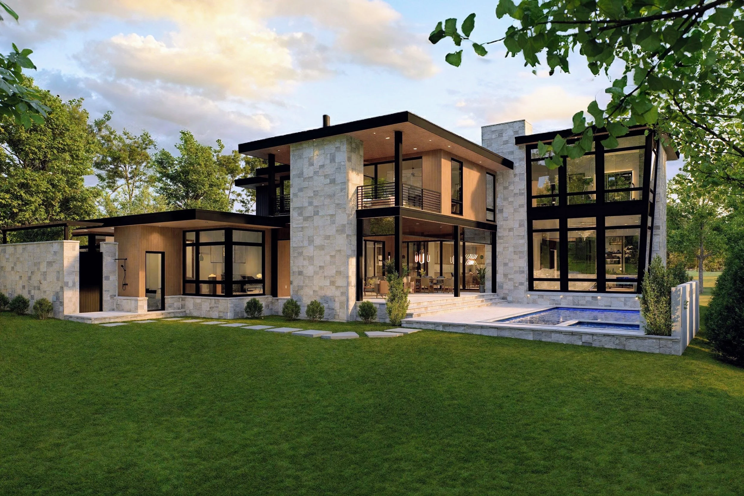 Modern house with large glass windows, stone and wood exterior, surrounded by a well-maintained lawn and trees during daytime.