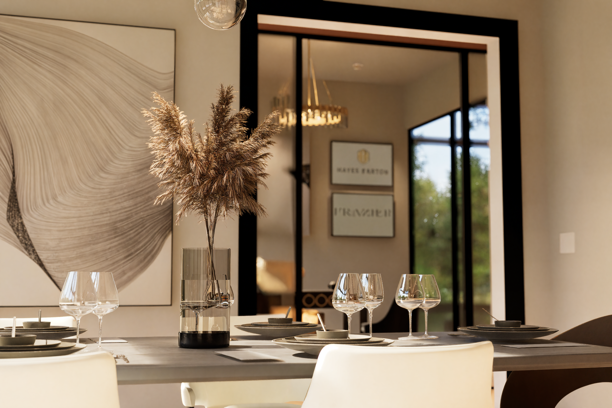 A modern dining room table set with four wine glasses, a small bowl, and a tall glass vase with dried pampas grass. In the background, there are wall art pieces, a reflection of a chandelier in a mirror, and a sliding glass door revealing an outdoor 