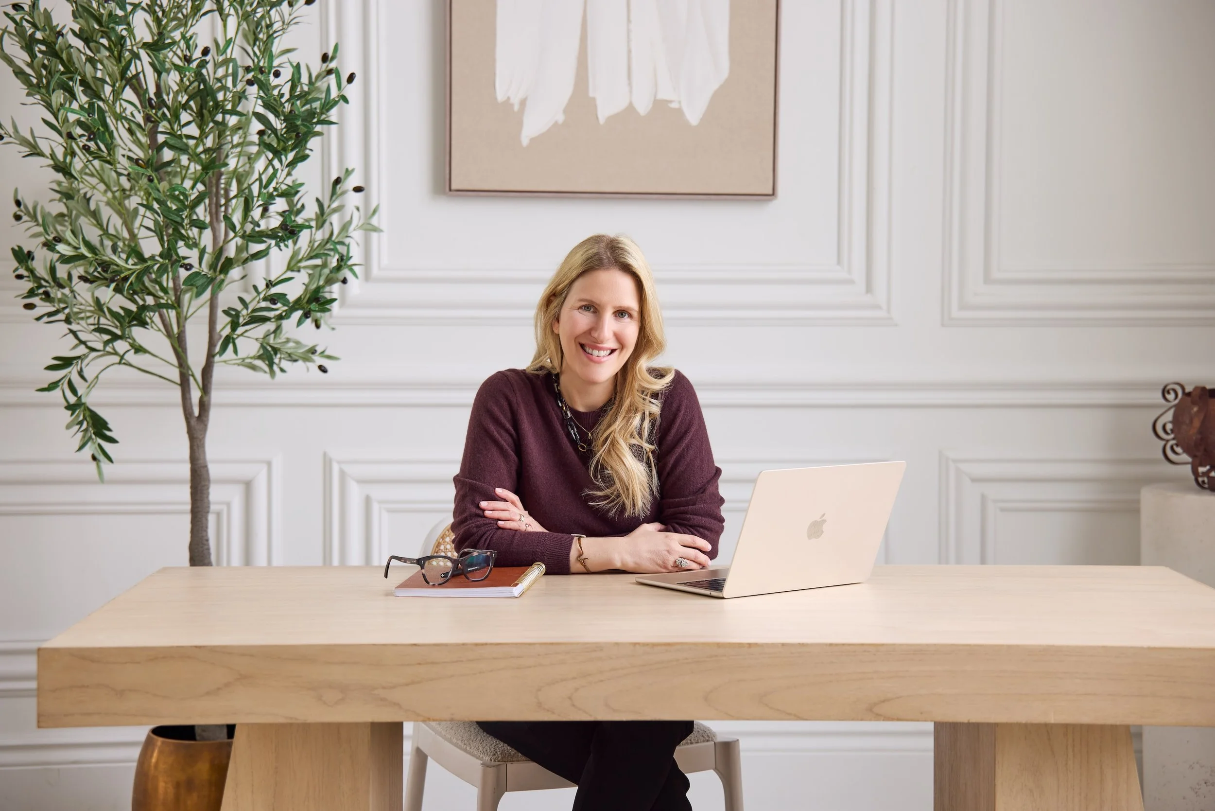 Career Coach Dana Rahat sits at a desk in Toronto Canada