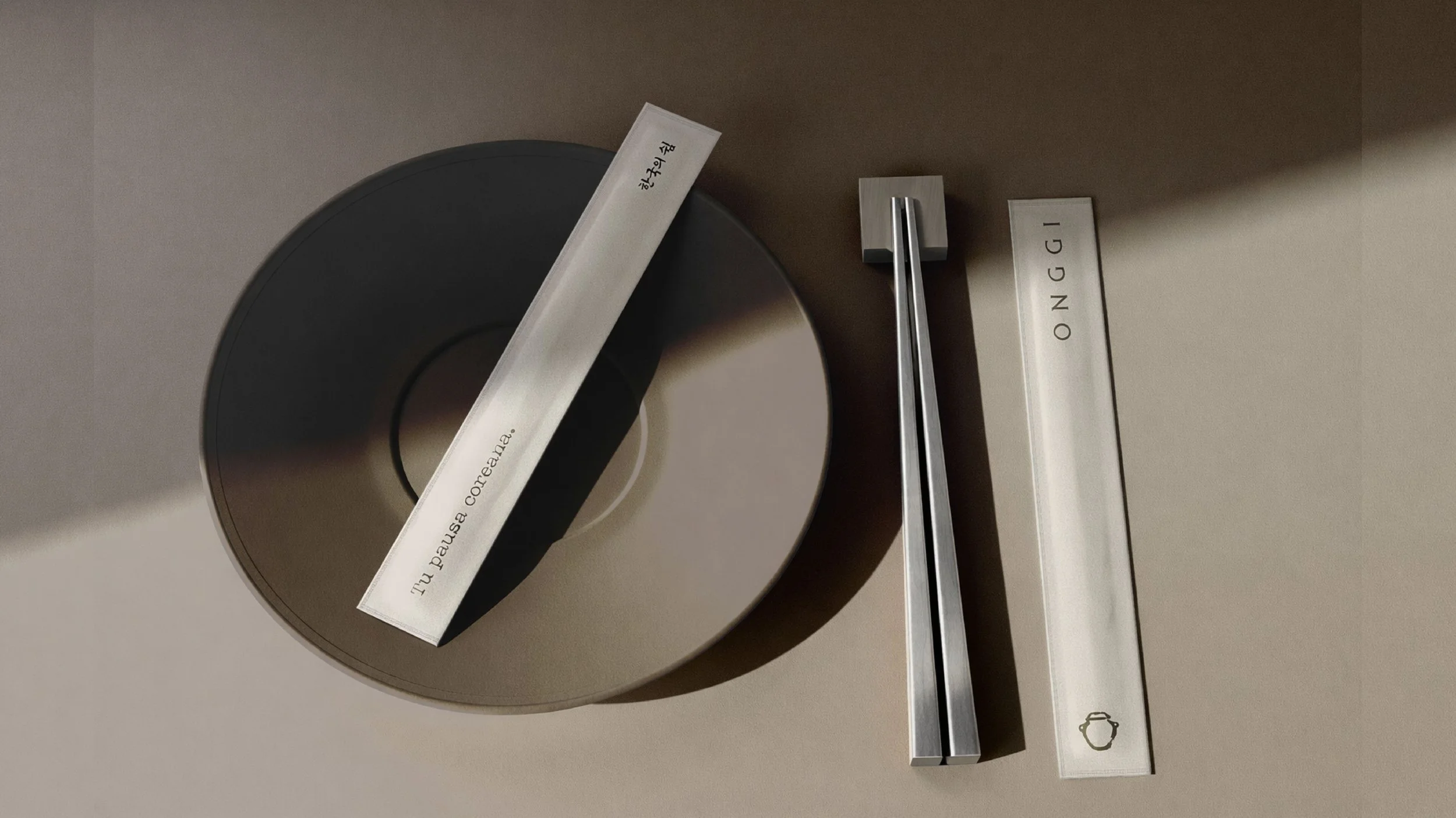 Objetos de cocina en un mostrador, incluyendo una espátula de metal, una caja con la palabra 'ONNGI' y una banda de papel con letras en un idioma no comprendido.