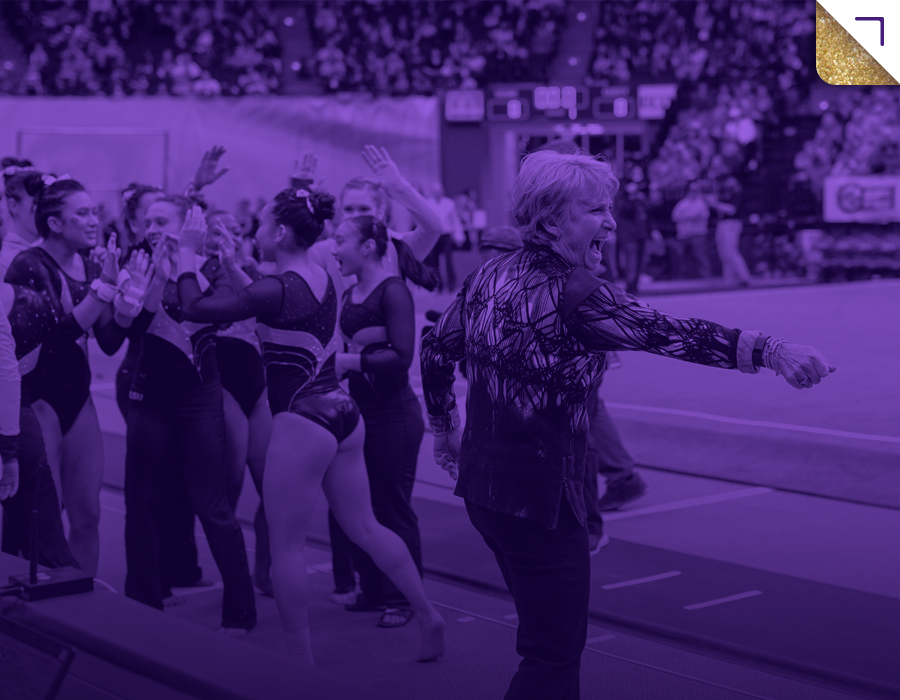 A coach enthusiastically cheering on a group of rhythmic gymnasts during a competition.