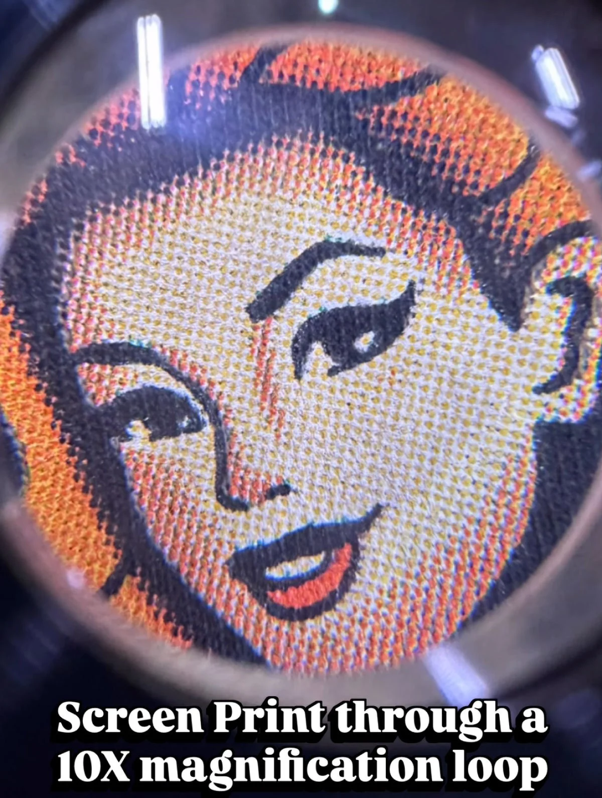 Close-up of a screen print of Marilyn Monroe's face under a 10x magnification loop.