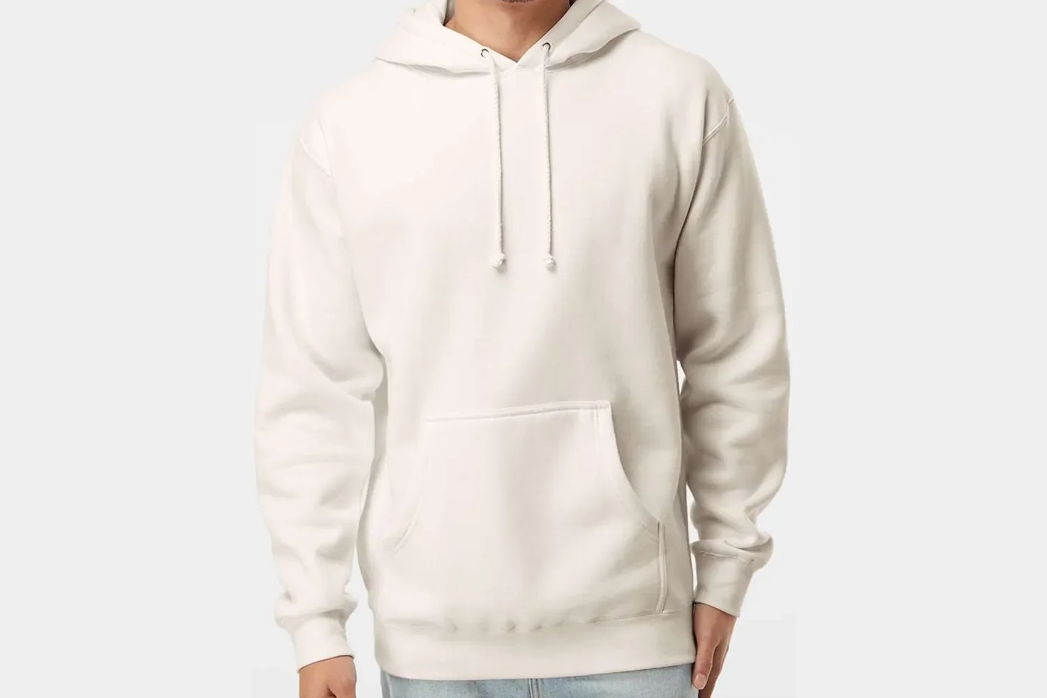A person wearing an off-white hoodie with a front pocket and drawstrings, standing against a plain light background.