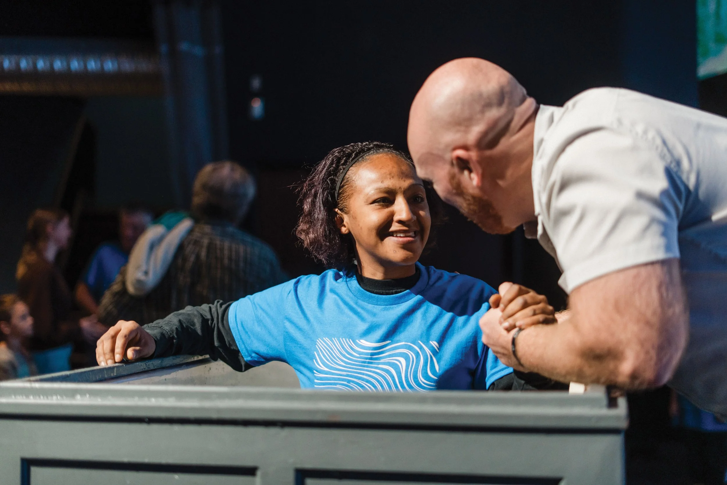 A smiling girl looks over at Pastor Christopher, readying herself for baptism.