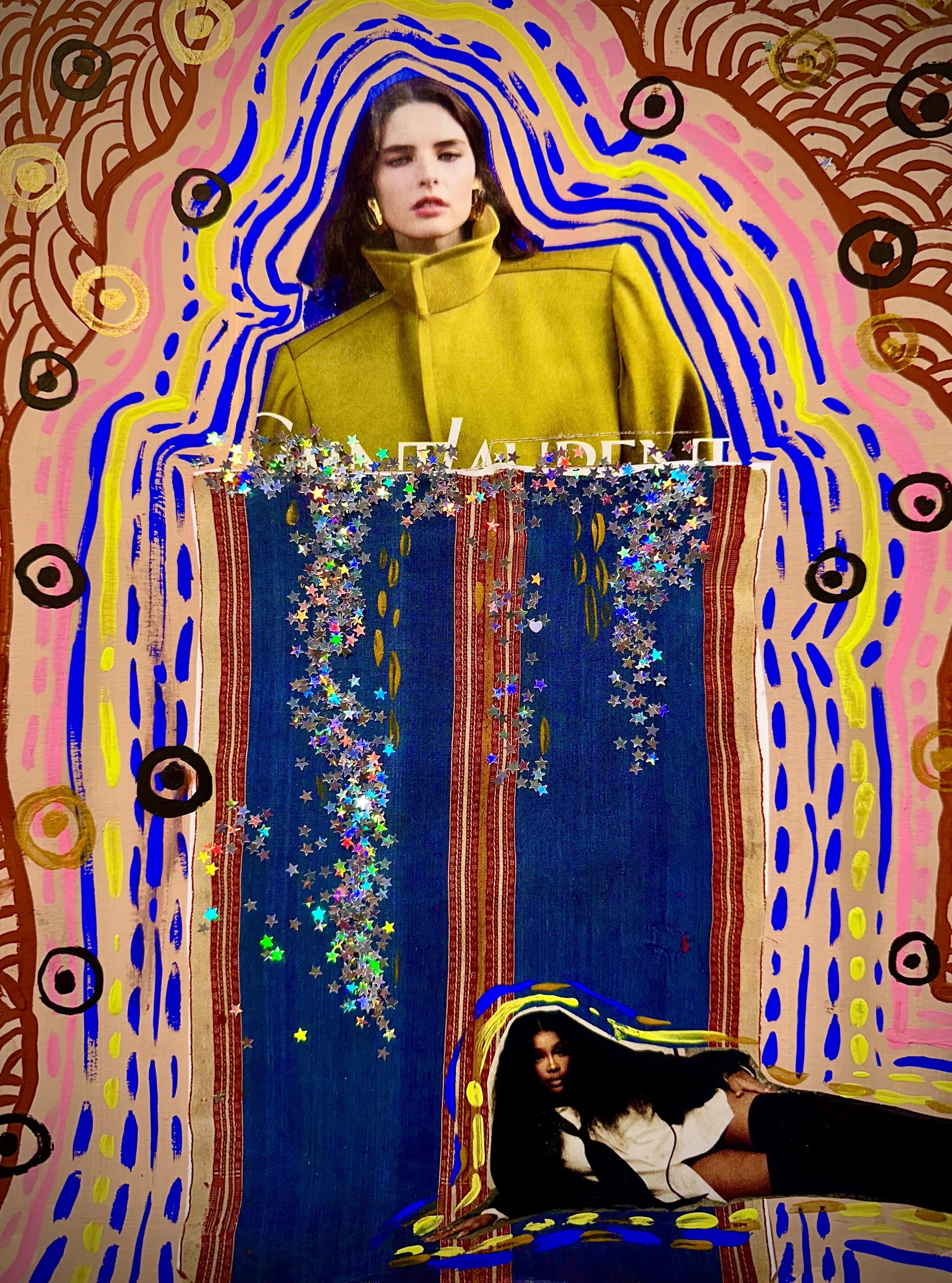 A woman is lying on the floor, propped up on her elbows, beneath a large, colorful, abstract artwork. The artwork features a woman with dark hair, wearing a yellow high-collared coat, surrounded by vibrant painted lines, circles, and patterns. There are multicolored star-shaped glitter scattered on the artwork, creating a sparkling effect.