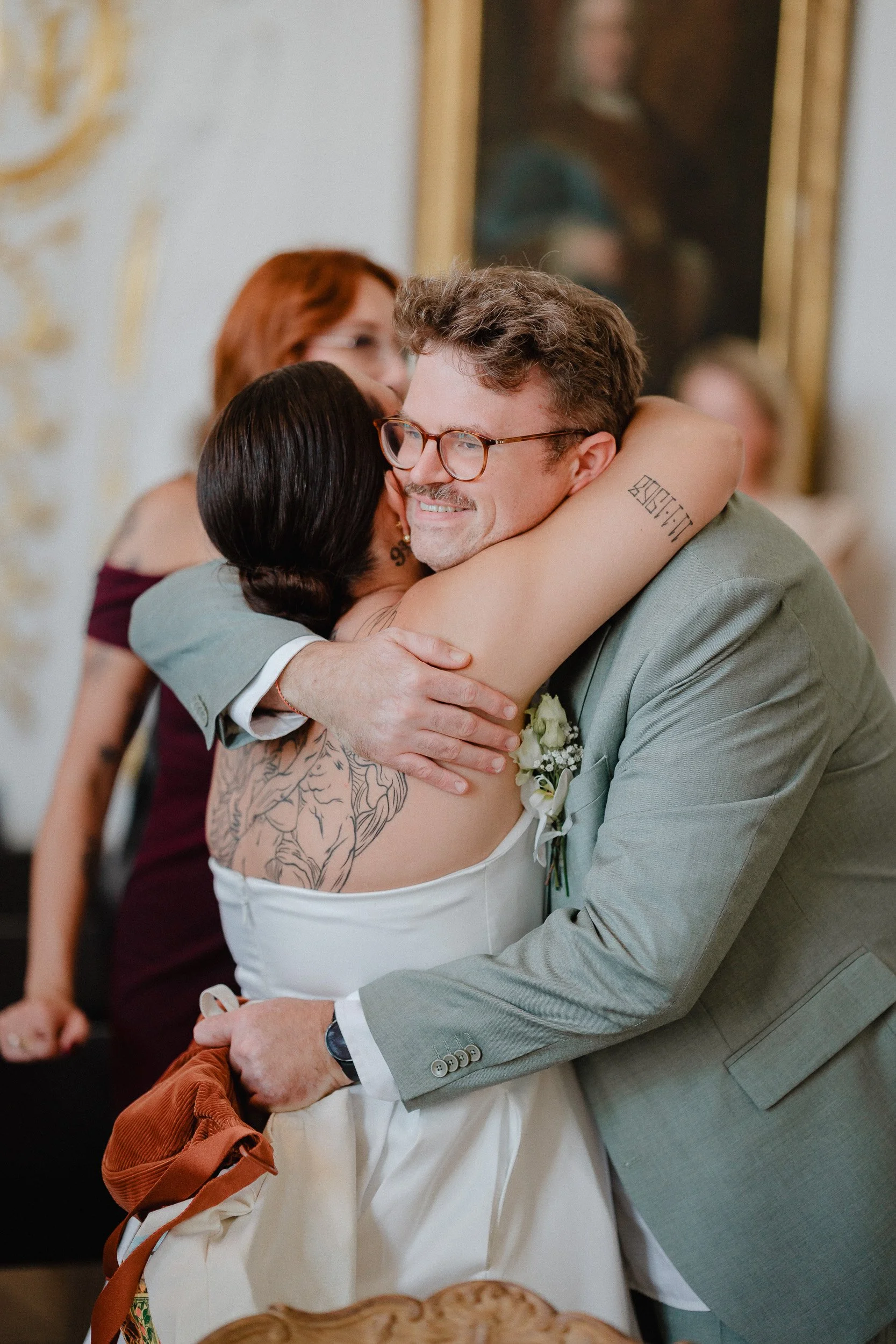 Paar bei einer Hochzeitsfeier, umarmt sich herzlich in einem festlichen Raum.