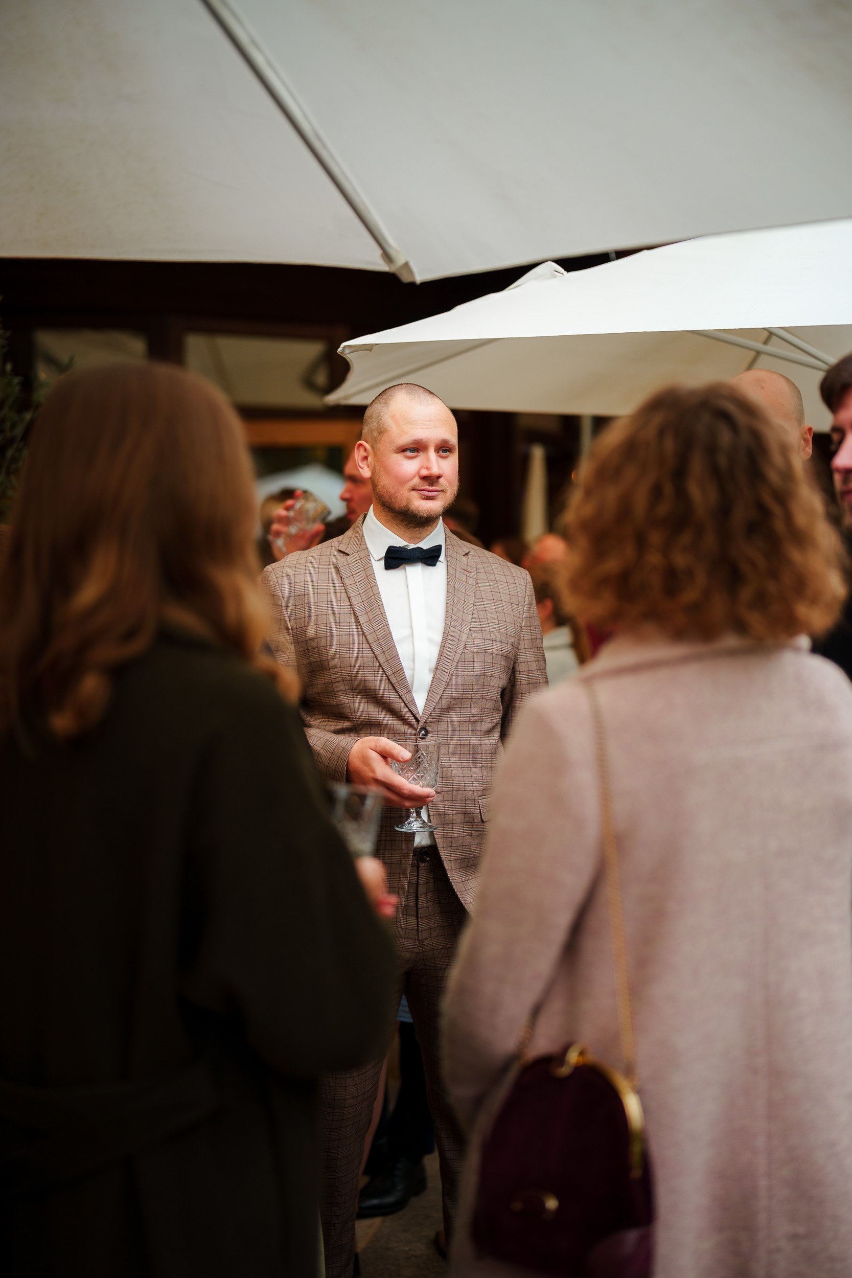 Mann in Anzug mit Fliege bei einer gesellschaftlichen Veranstaltung im Freien