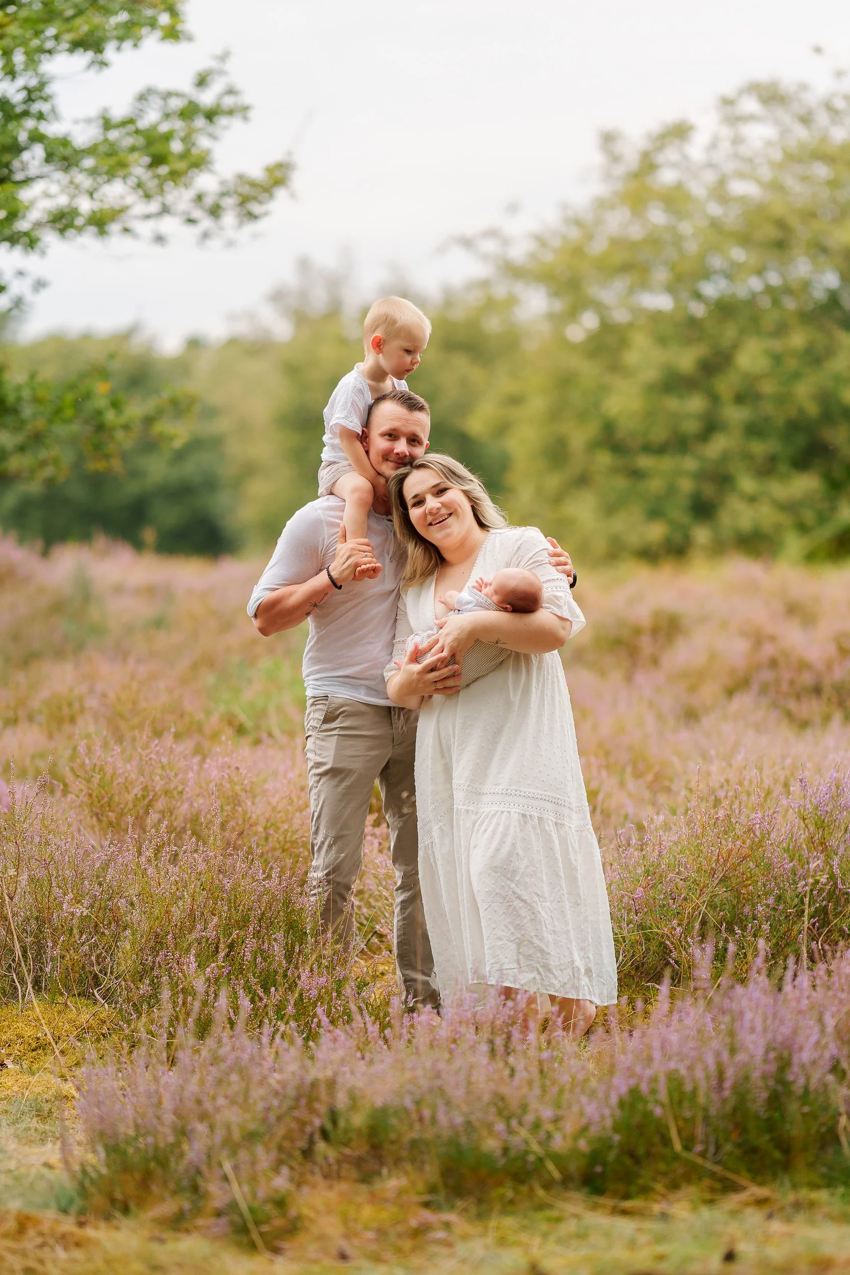 Familie mit zwei kleinen Kindern im Blumenfeld bei Sonnenuntergang