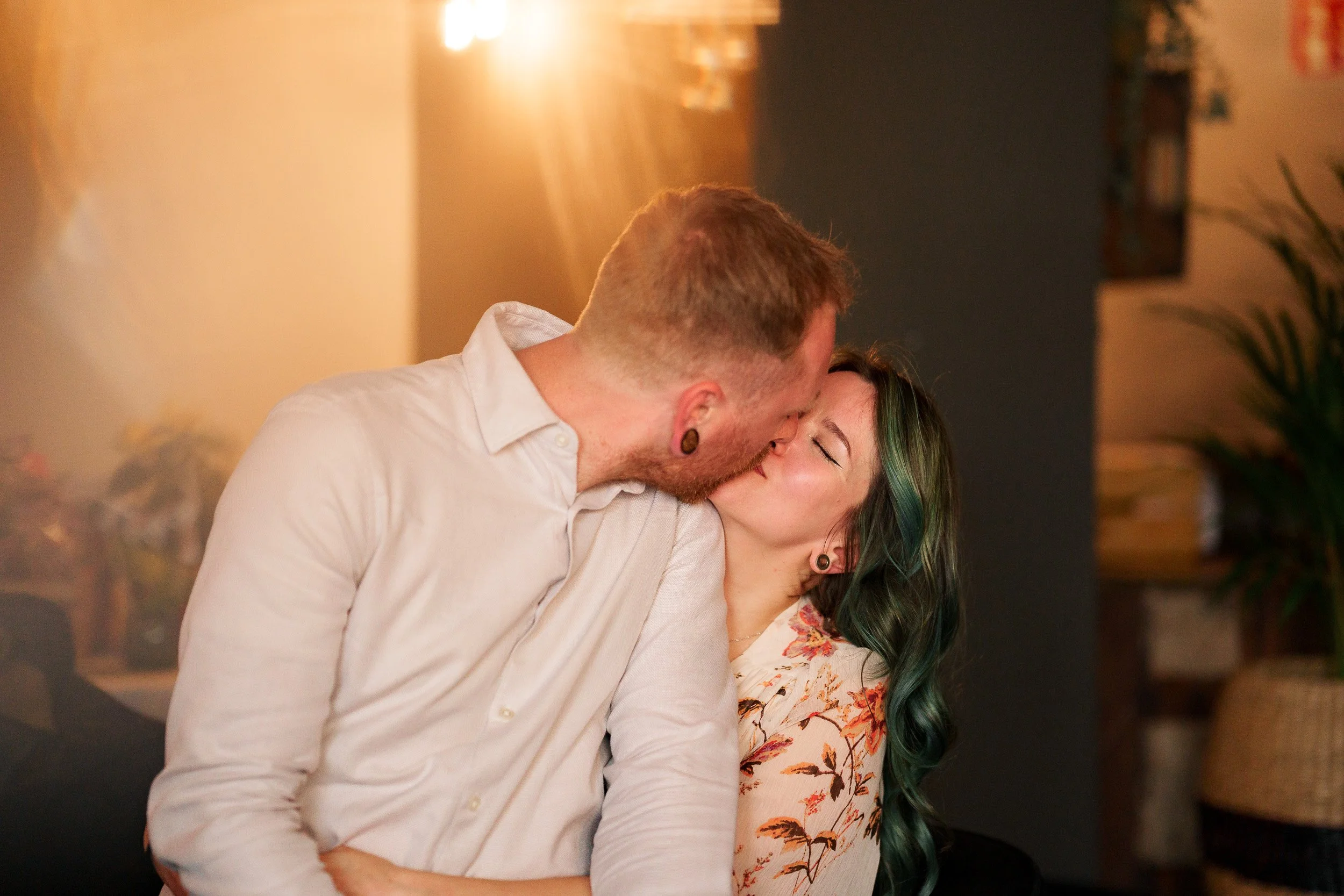 Ein verliebtes Paar küsst sich in einem gemütlichen Raum.