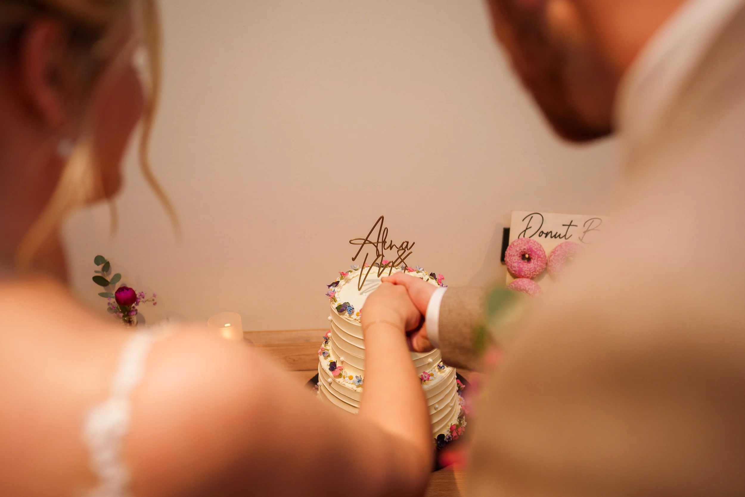 Ein Brautpaar schneidet eine Hochzeitstorte gemeinsam.