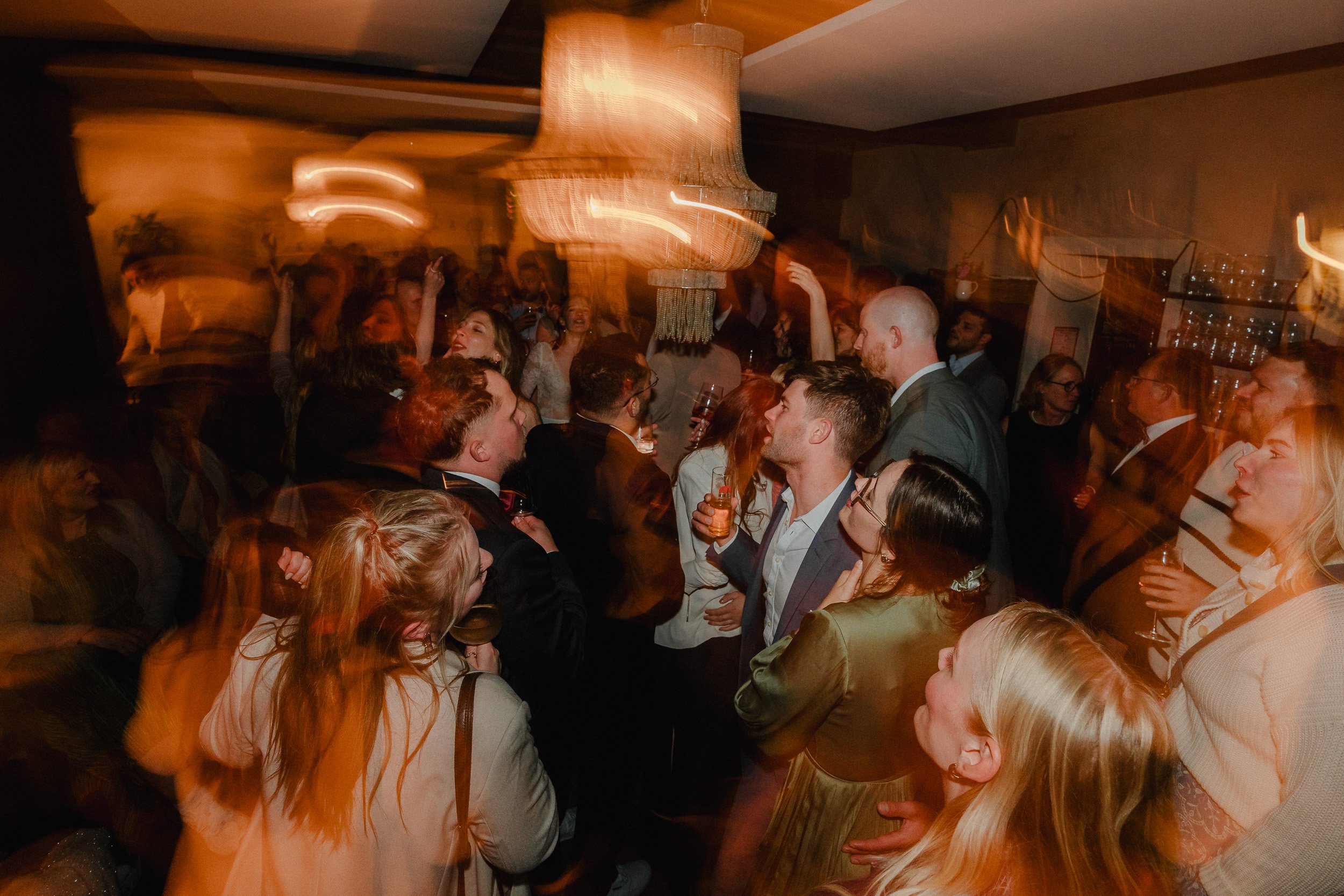 Menschen feiern und tanzen auf einer Party in einem festlich dekorierten Raum.