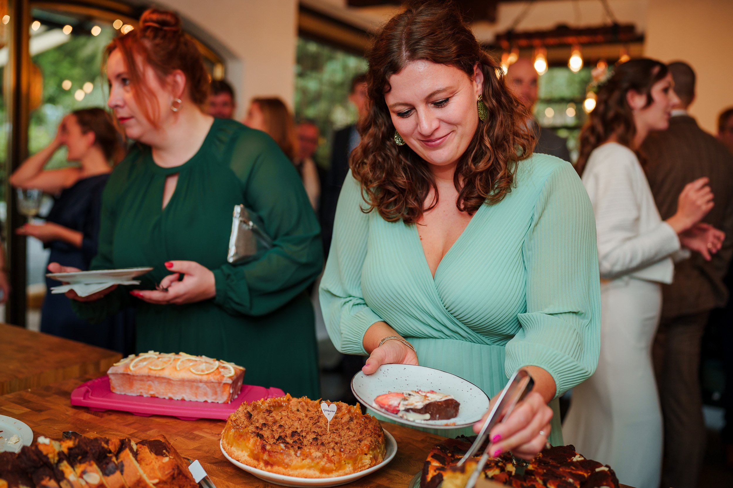 Frauen beim Buffet mit Kuchen und Desserts auf einem festlichen Ereignis