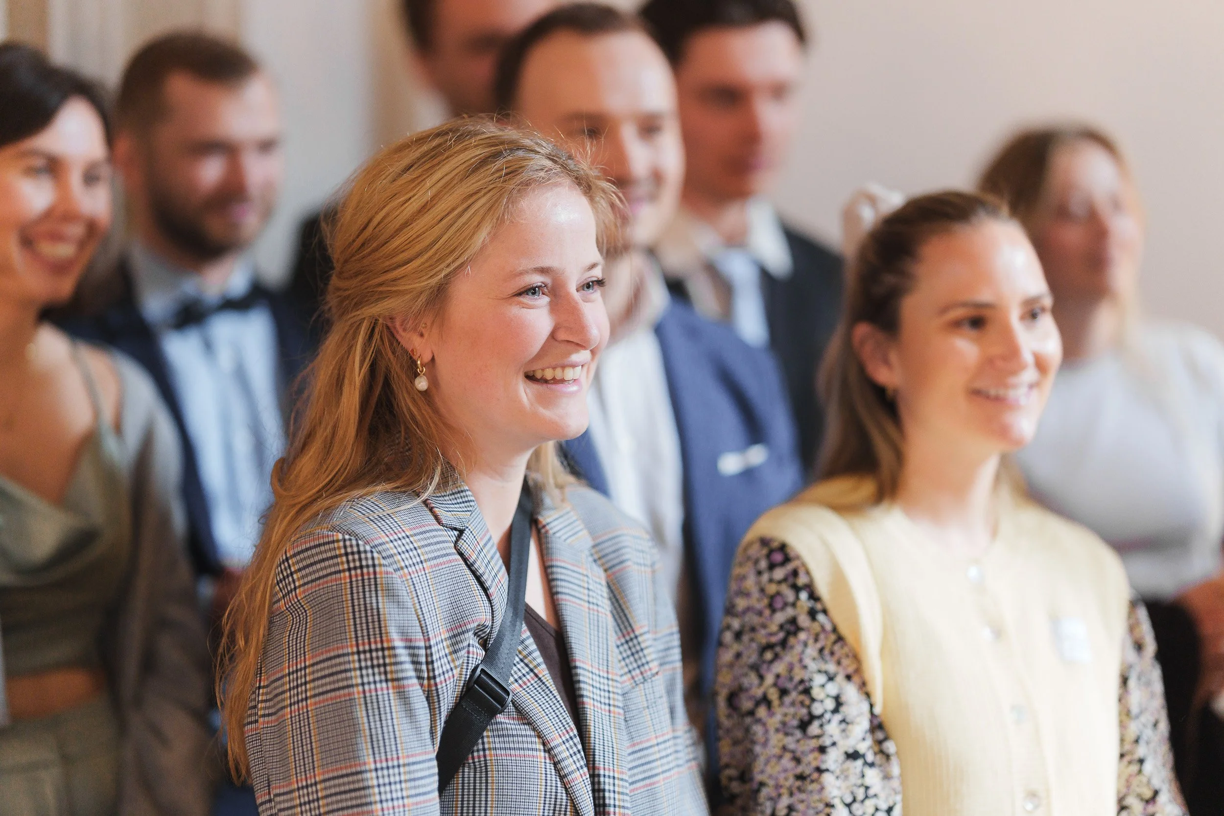 Gruppe von jungen Erwachsenen, die bei einer Veranstaltung lächeln.