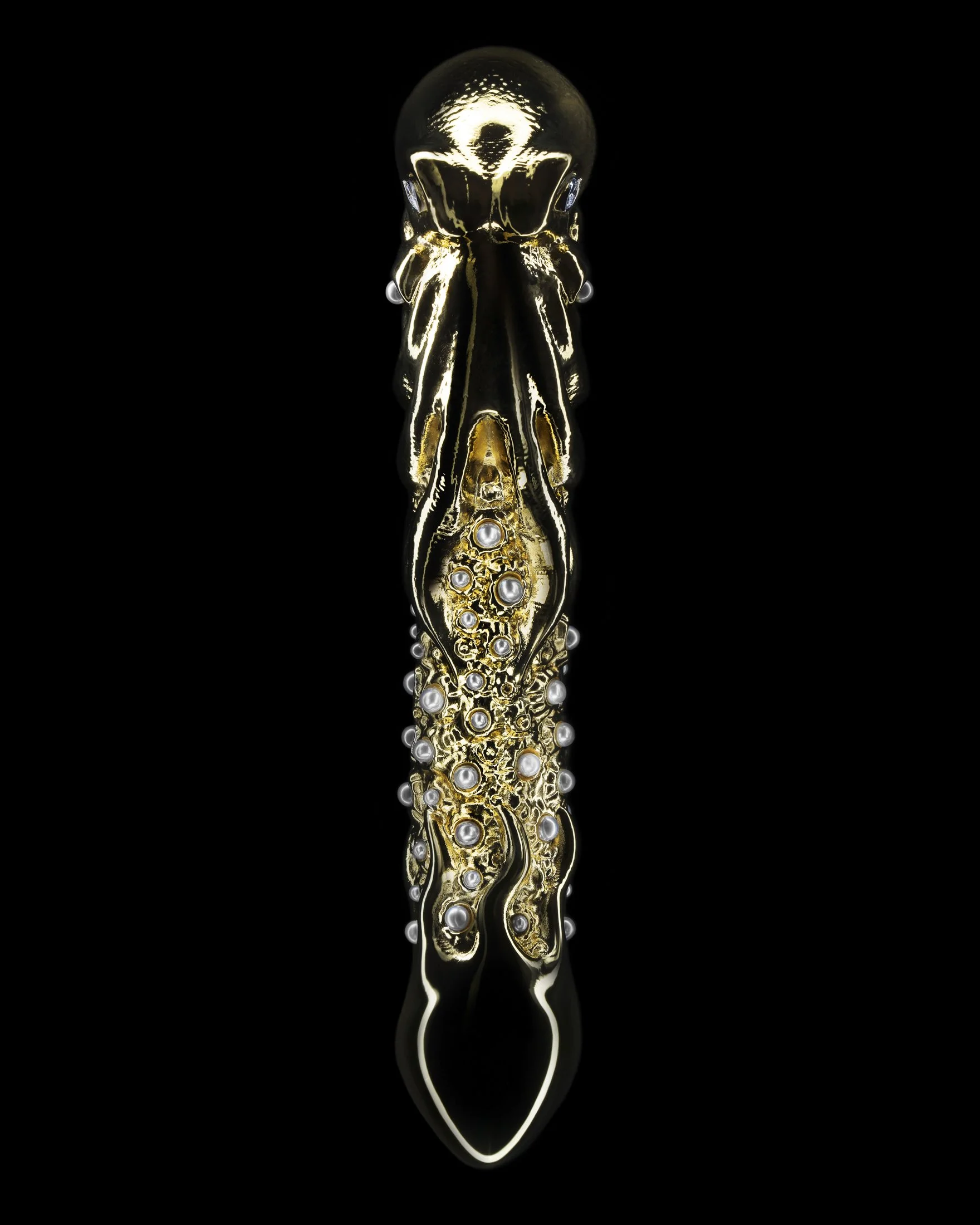 Gold-colored snake-shaped brooch decorated with pearls, set against a black background.