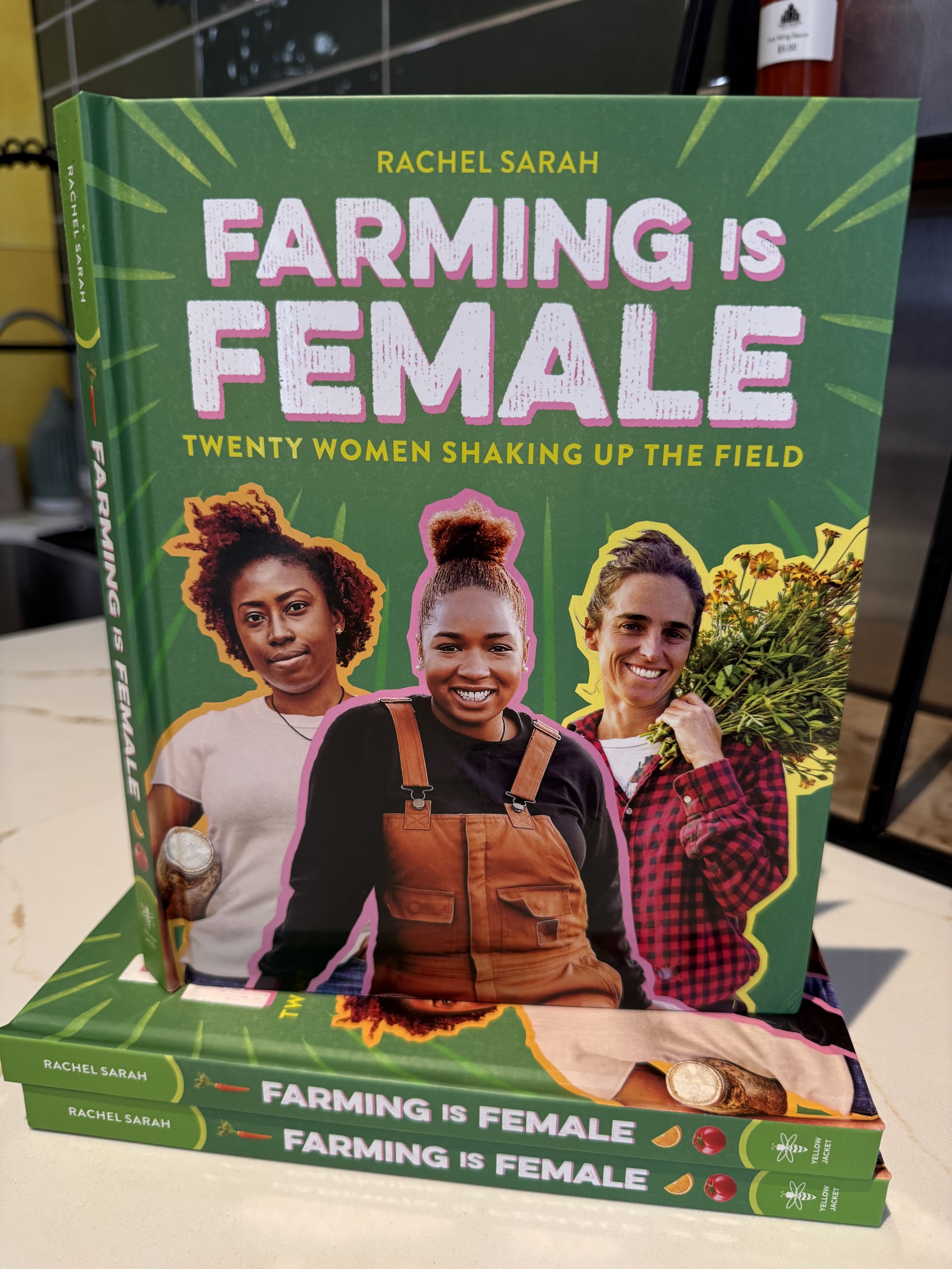 Three women smiling on the cover of a book titled 'Farming is Female: Twenty Women Shaking Up the Field'. The women are diverse in appearance; one has curly hair, another has an updo hairstyle, and the third is holding a bouquet of yellow flowers. The background is green with yellow accents.