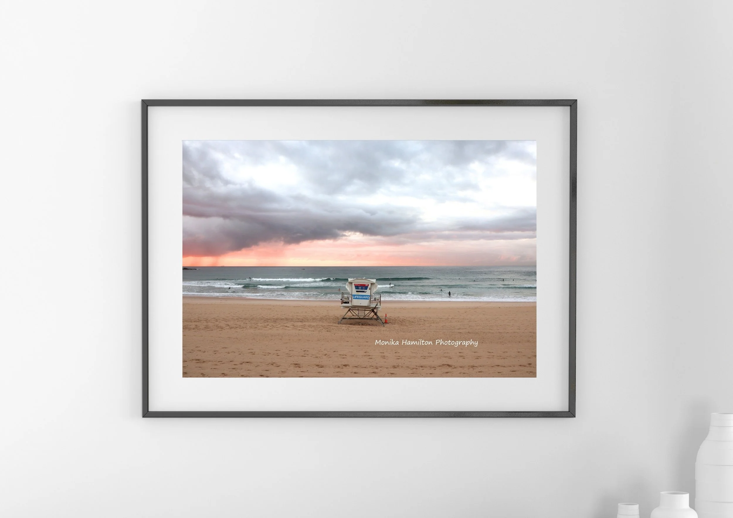 Sunrise at Bondi Beach in New South Wales, Australia - a lifeguard chair faces the cloudy, pastel sky and teal waves. 