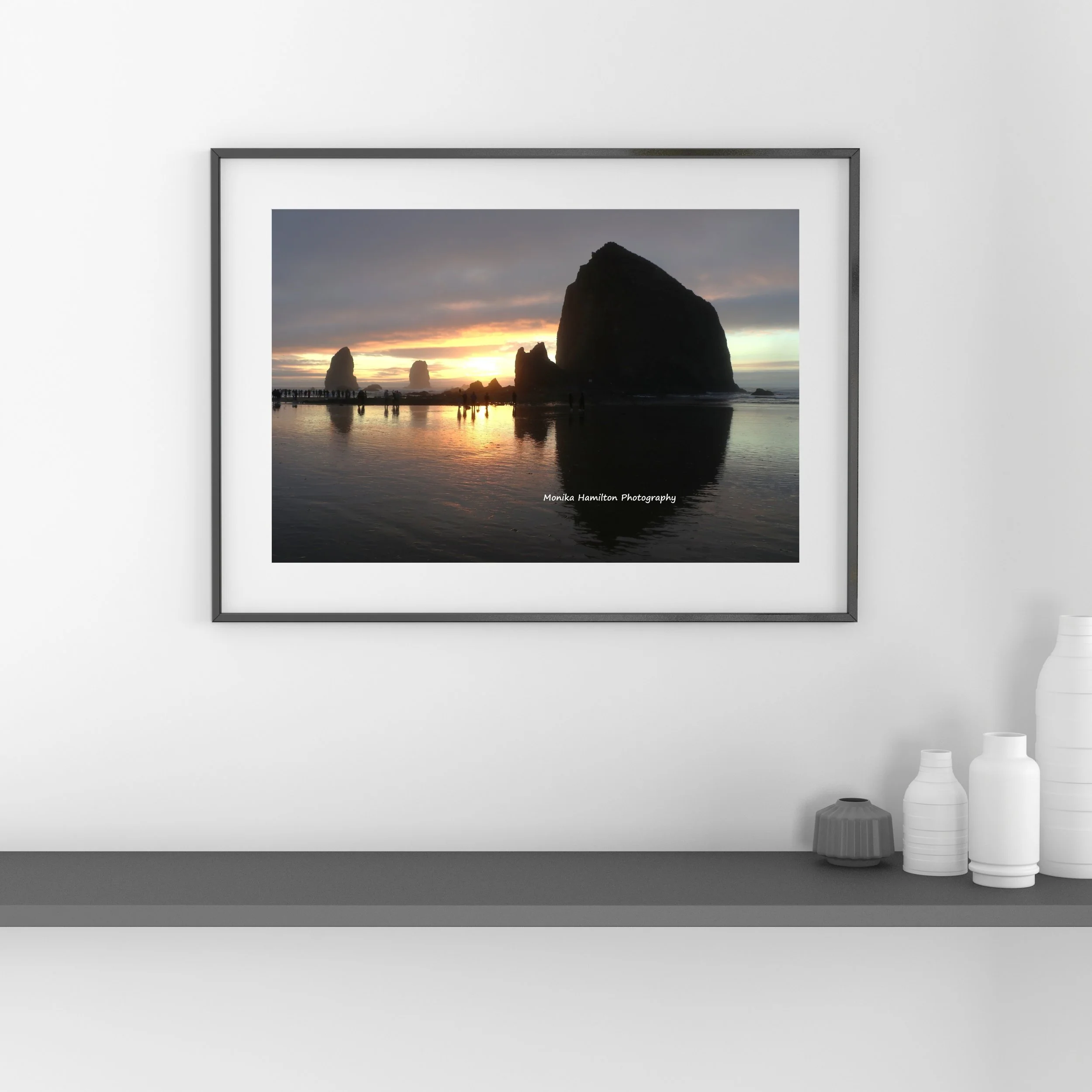 Sunset over the Haystack Rock at Cannon Beach, Oregon - landscape photograph with reflections and silhouettes.