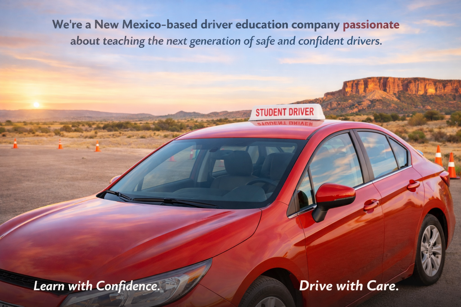 A red driver education car with a 'Student Driver' sign on top, parked in a desert area with mountains in the background at sunset.