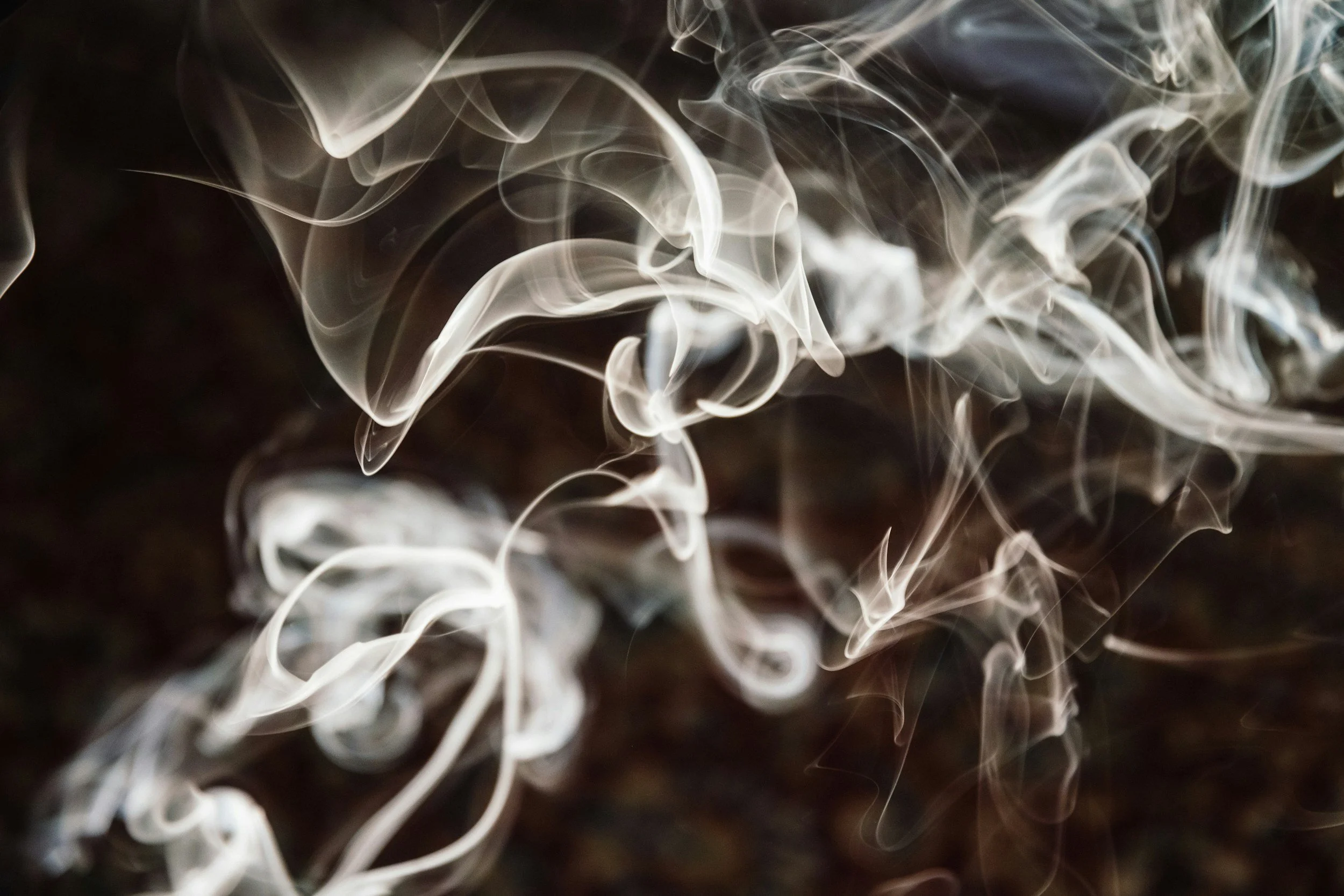 Swirling white smoke against a dark background.