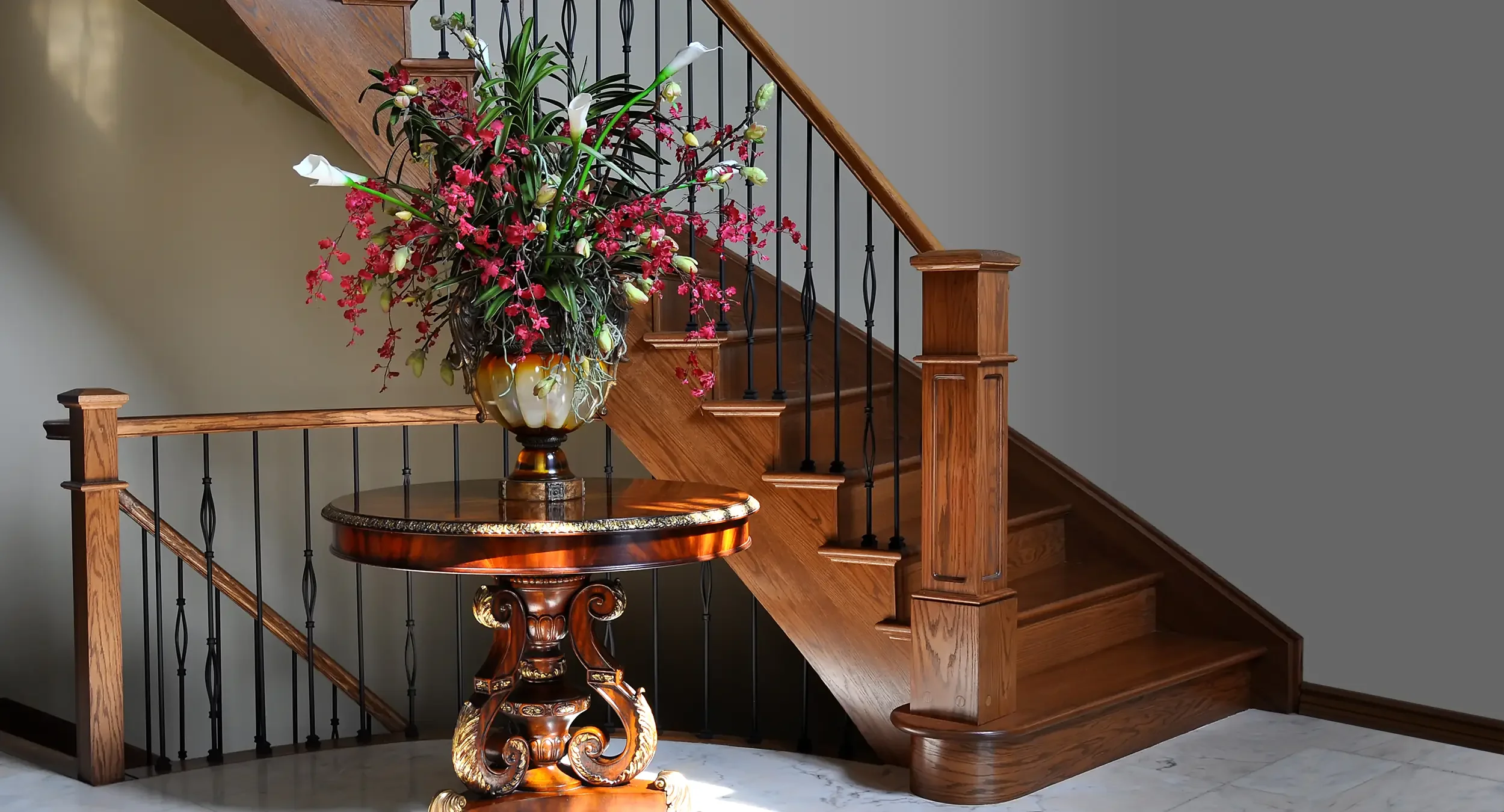 An elegant curved oak staircase with custom box newel and satin black metal spindles, installed by Campbell's Woodcraft in Nepean, Ottawa.