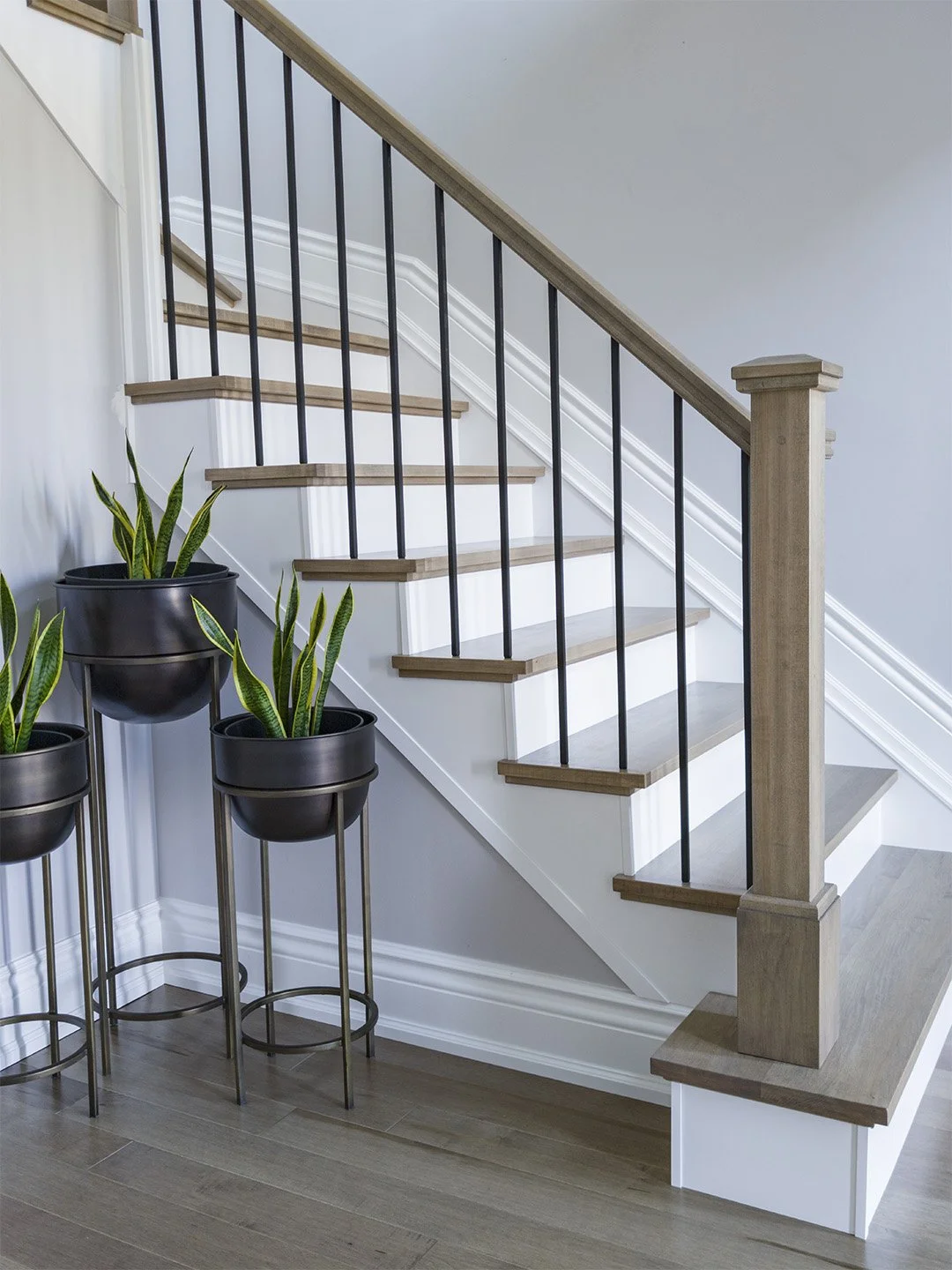 A maple contemporary handrail with box newel post and plain satin black metal spindles installed by Campbell's Woodcraft in Kanata, Ottawa. 