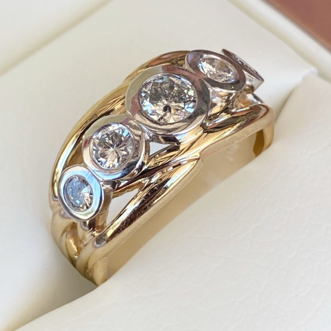 Gold ring with five small gemstones arranged in a row, set in alternating silver and gold-colored settings.