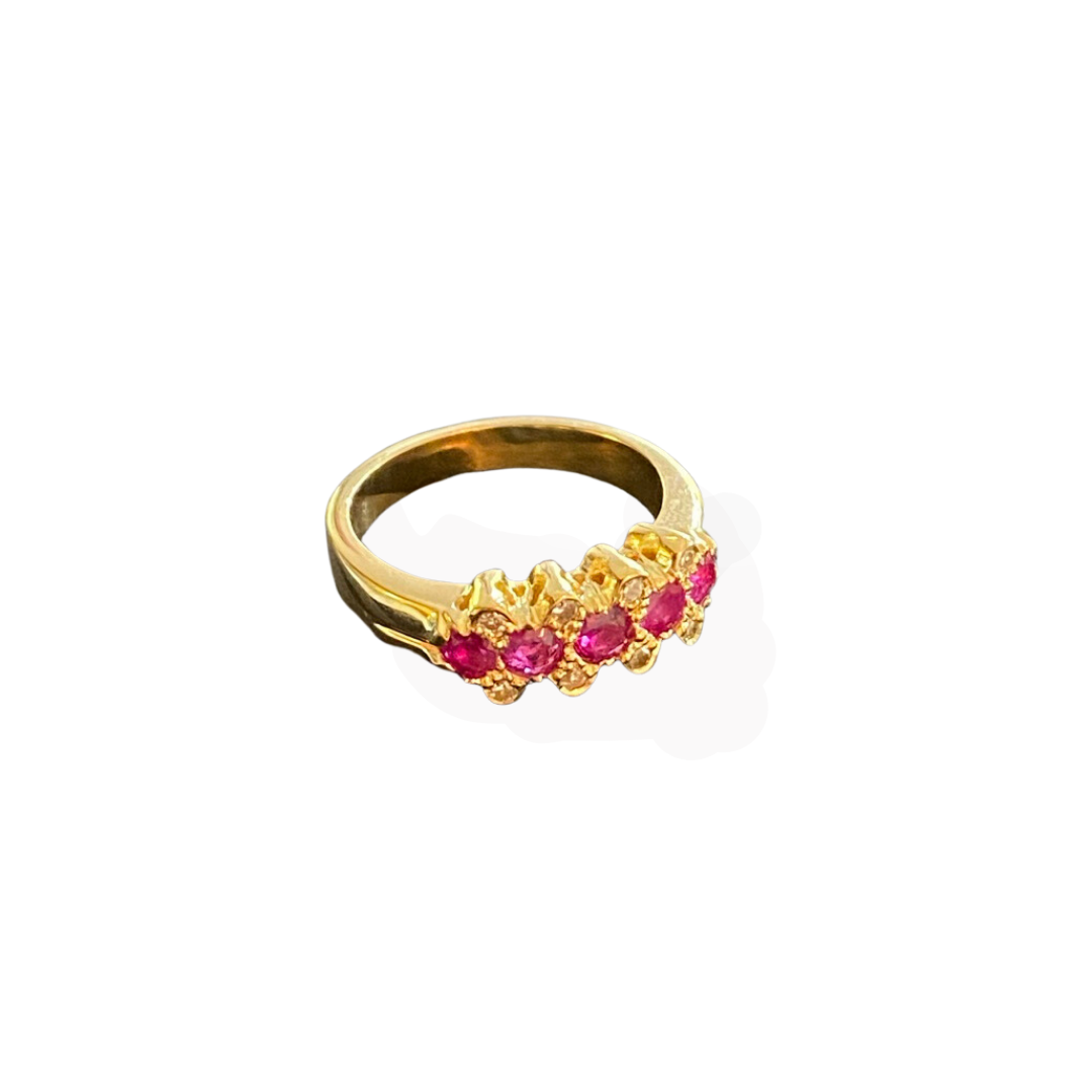 Gold ring with pink gemstones on a white background.