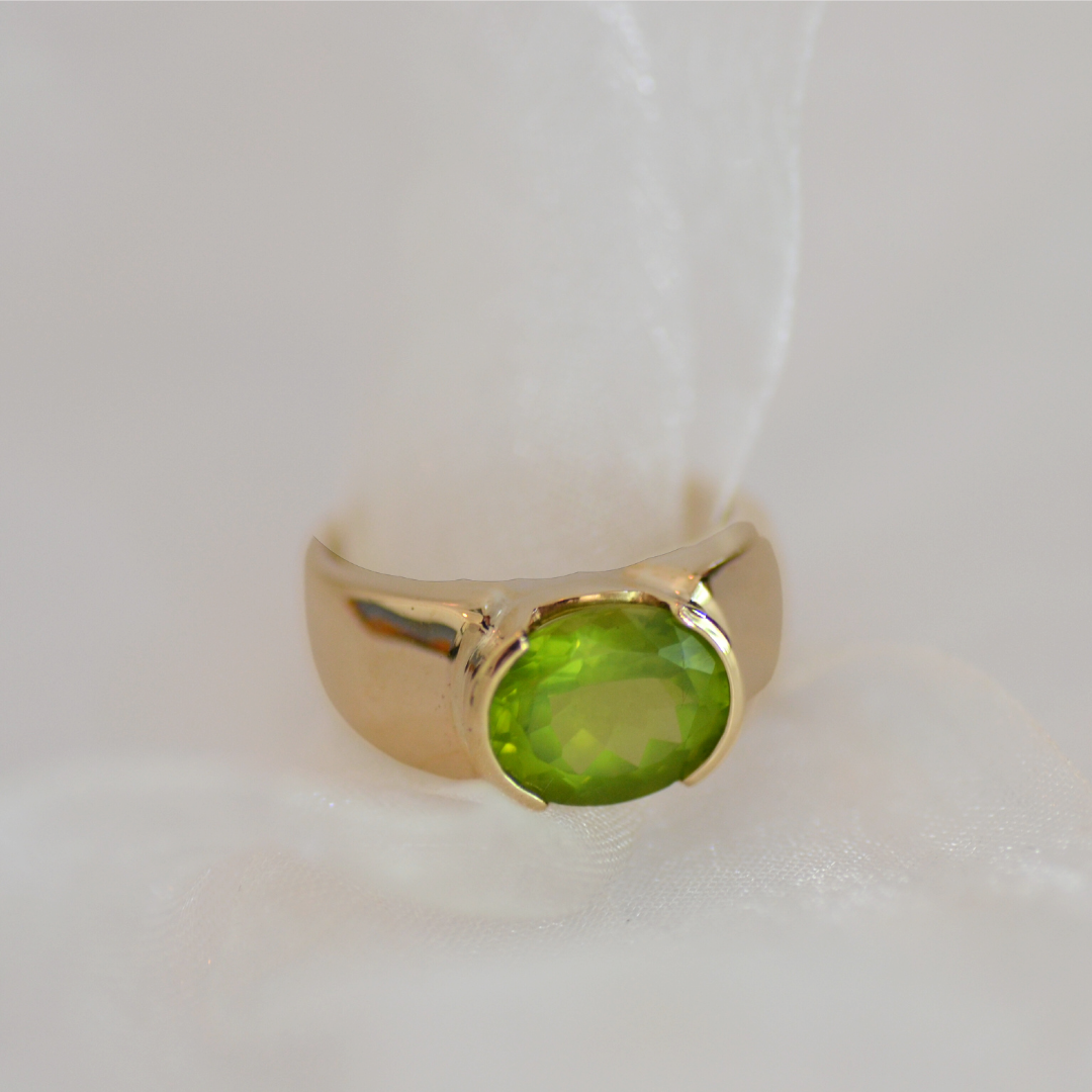 Gold ring with a large round green gemstone