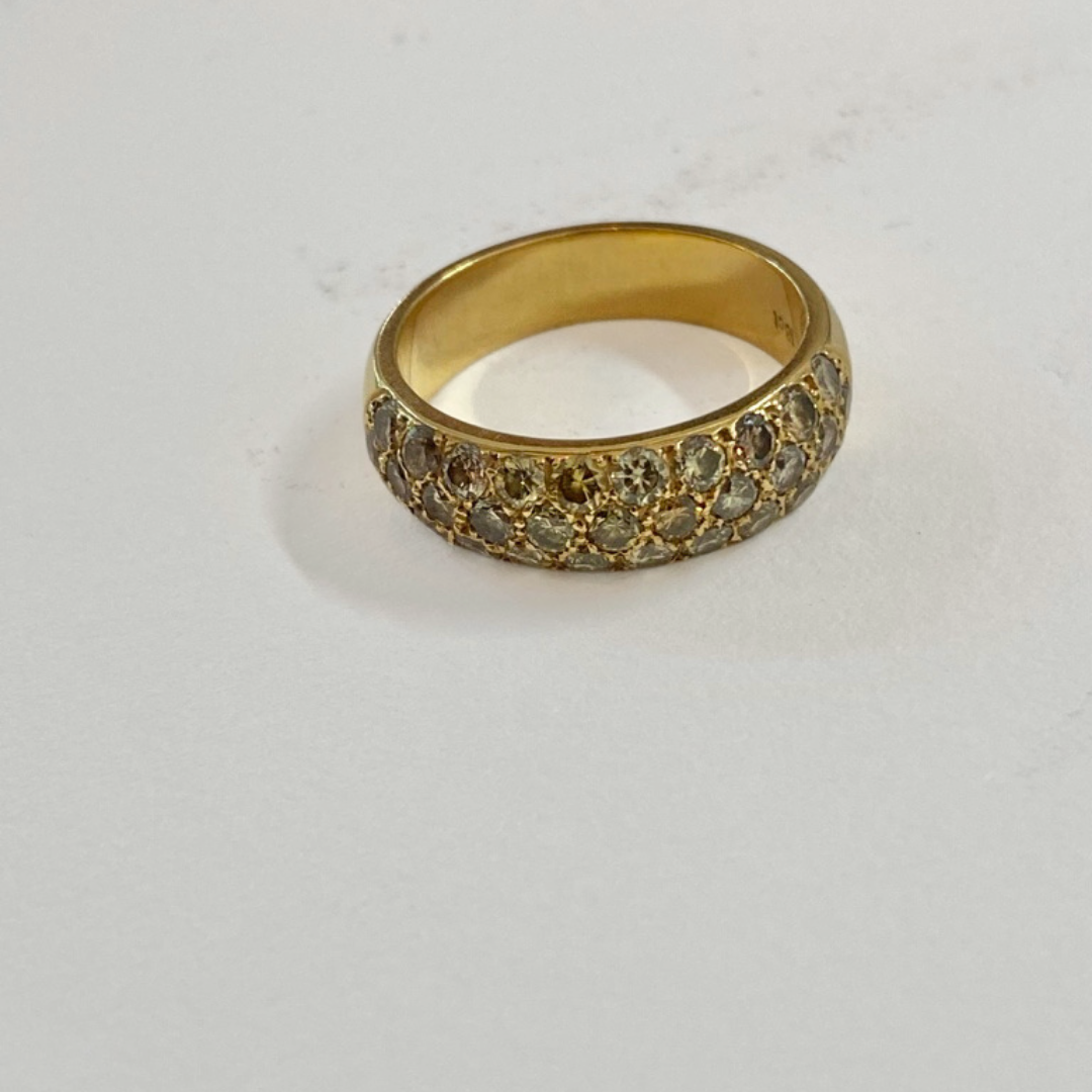 Gold ring with multiple small diamonds embedded around its circumference.