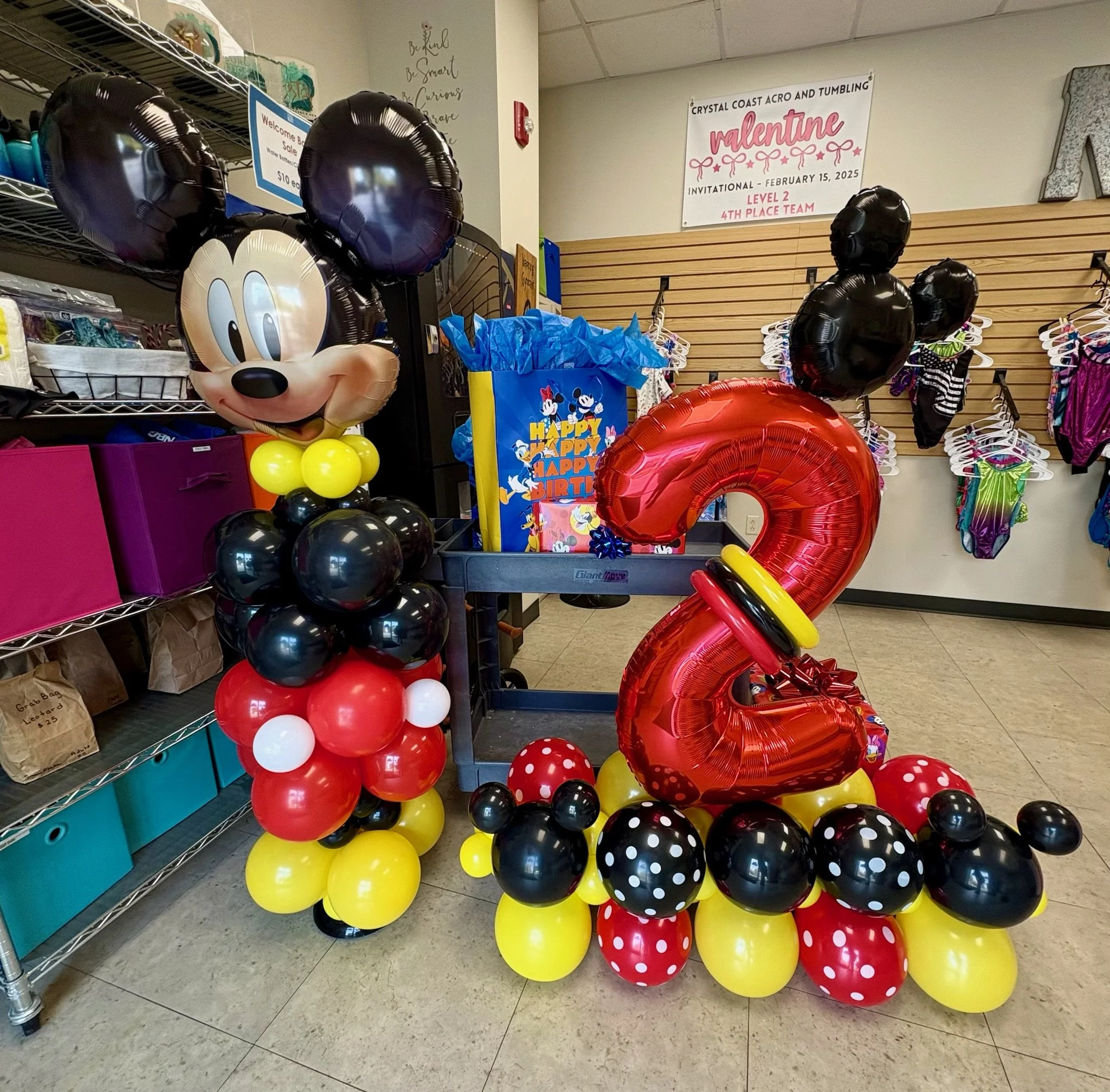 Mickey Mouse–themed balloon sculpture with a red number two balloon