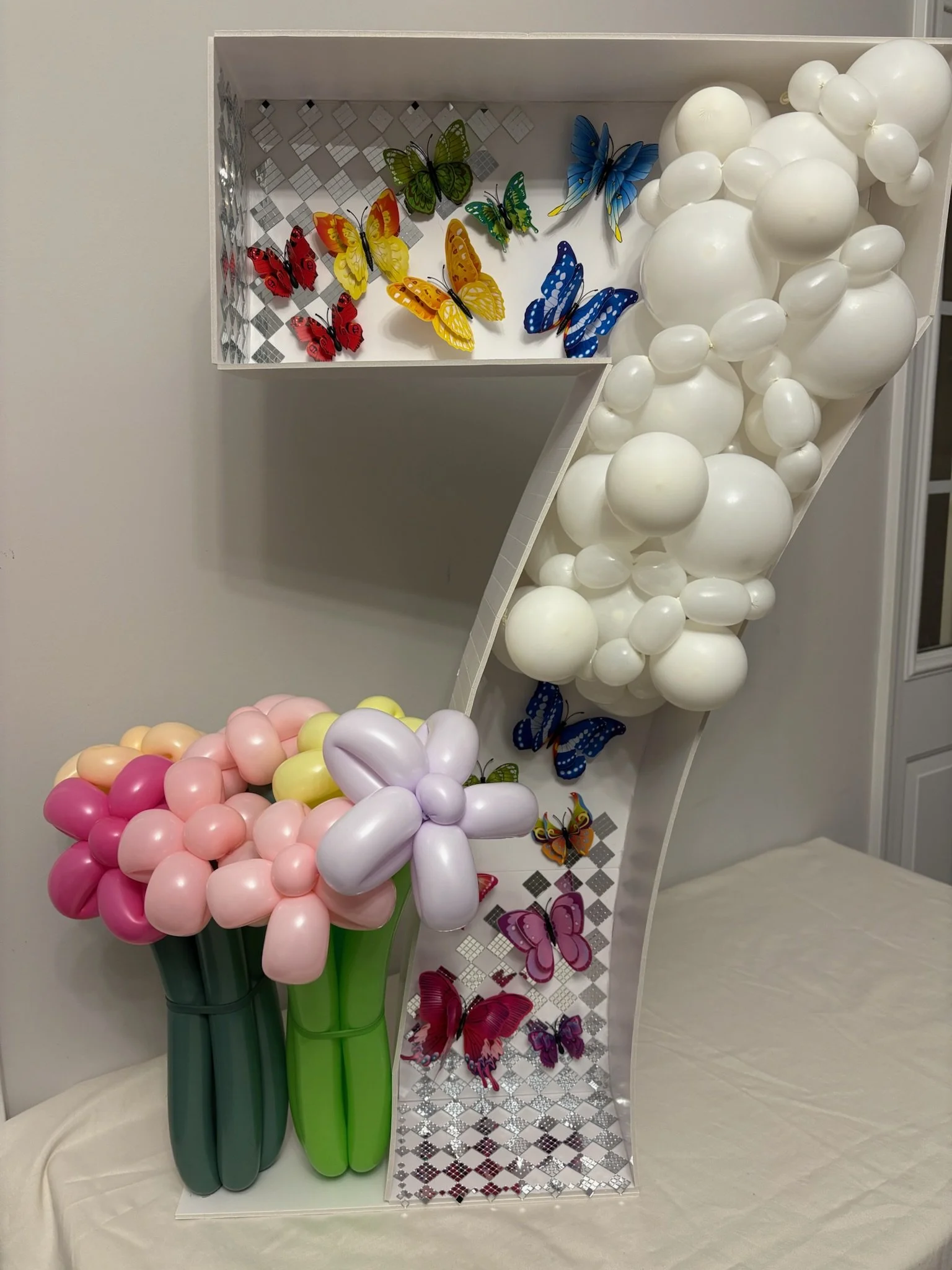 Balloon garland inside of number seven made from cardboard with pastel flower balloon accents