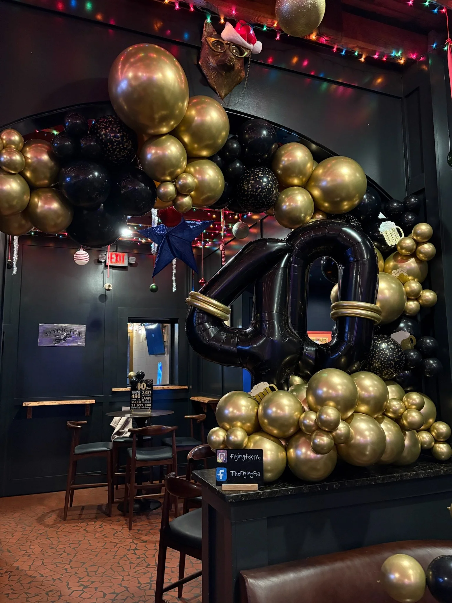 Black and gold balloon installation with large number forty for milestone birthday