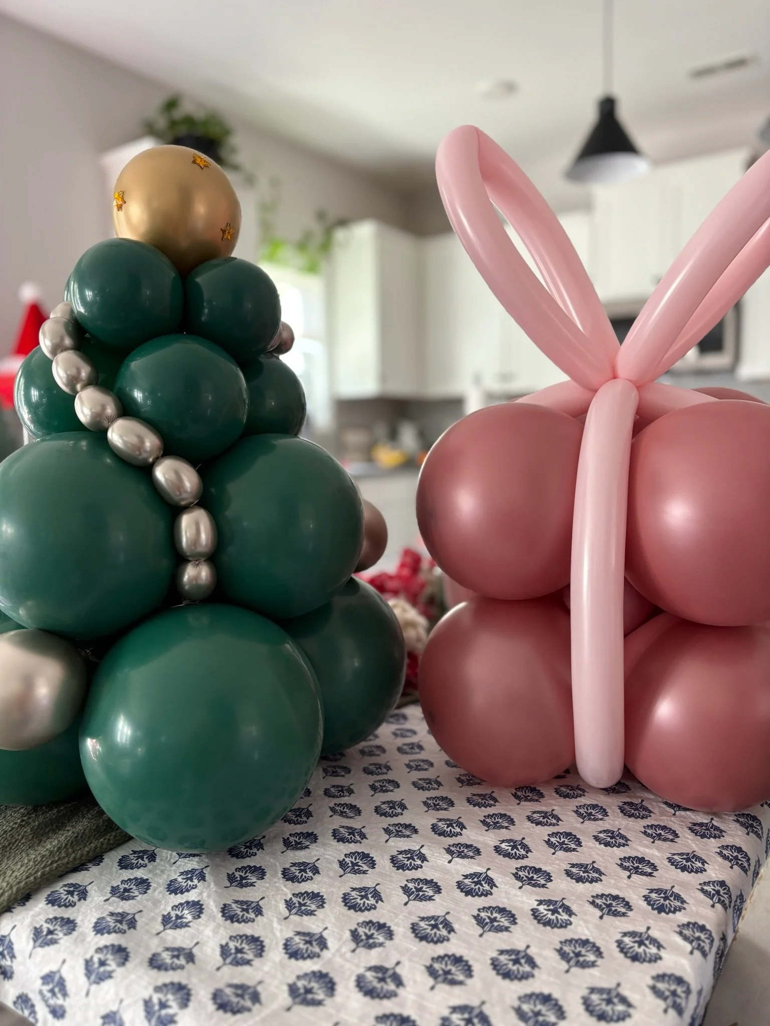 Holiday balloon sculptures shaped like a Christmas tree and a gift
