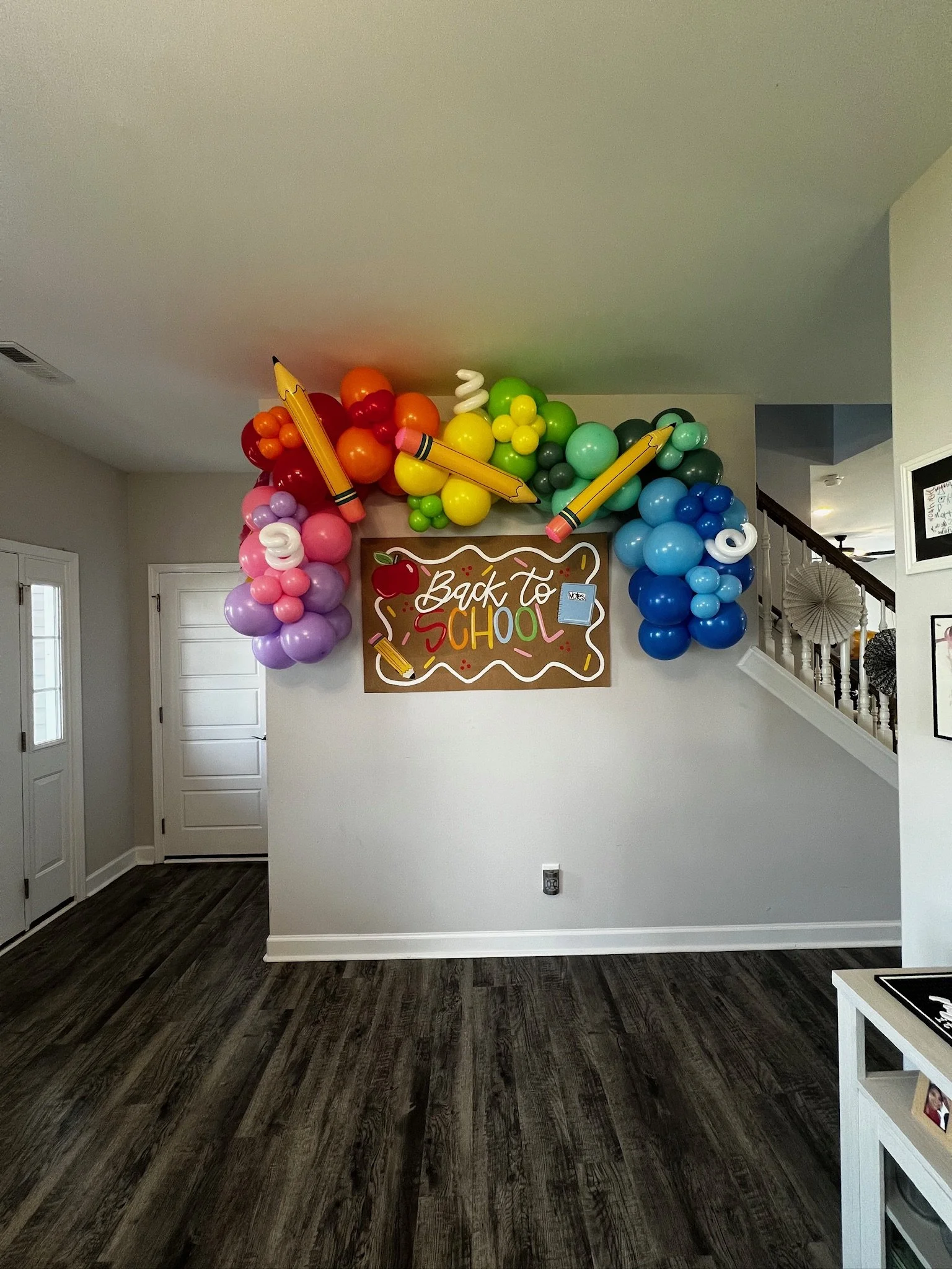 Back-to-school balloon arch with colorful balloons and school-themed accents in a home entryway