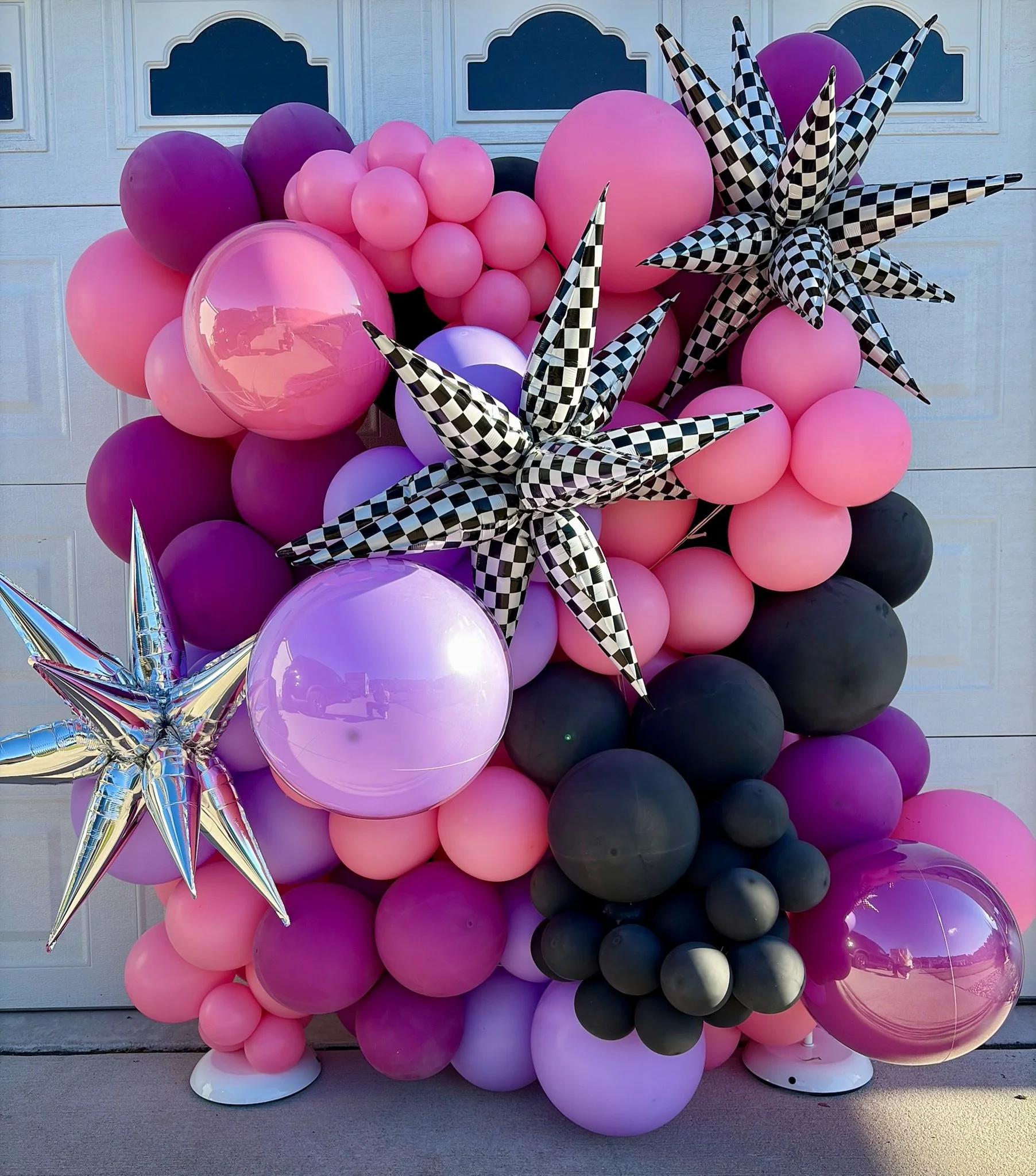 Pink, purple, and black balloon display with starburst foil accents
