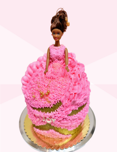 A cake decorated to look like a pink princess dress with a Barbie doll figurine on top.