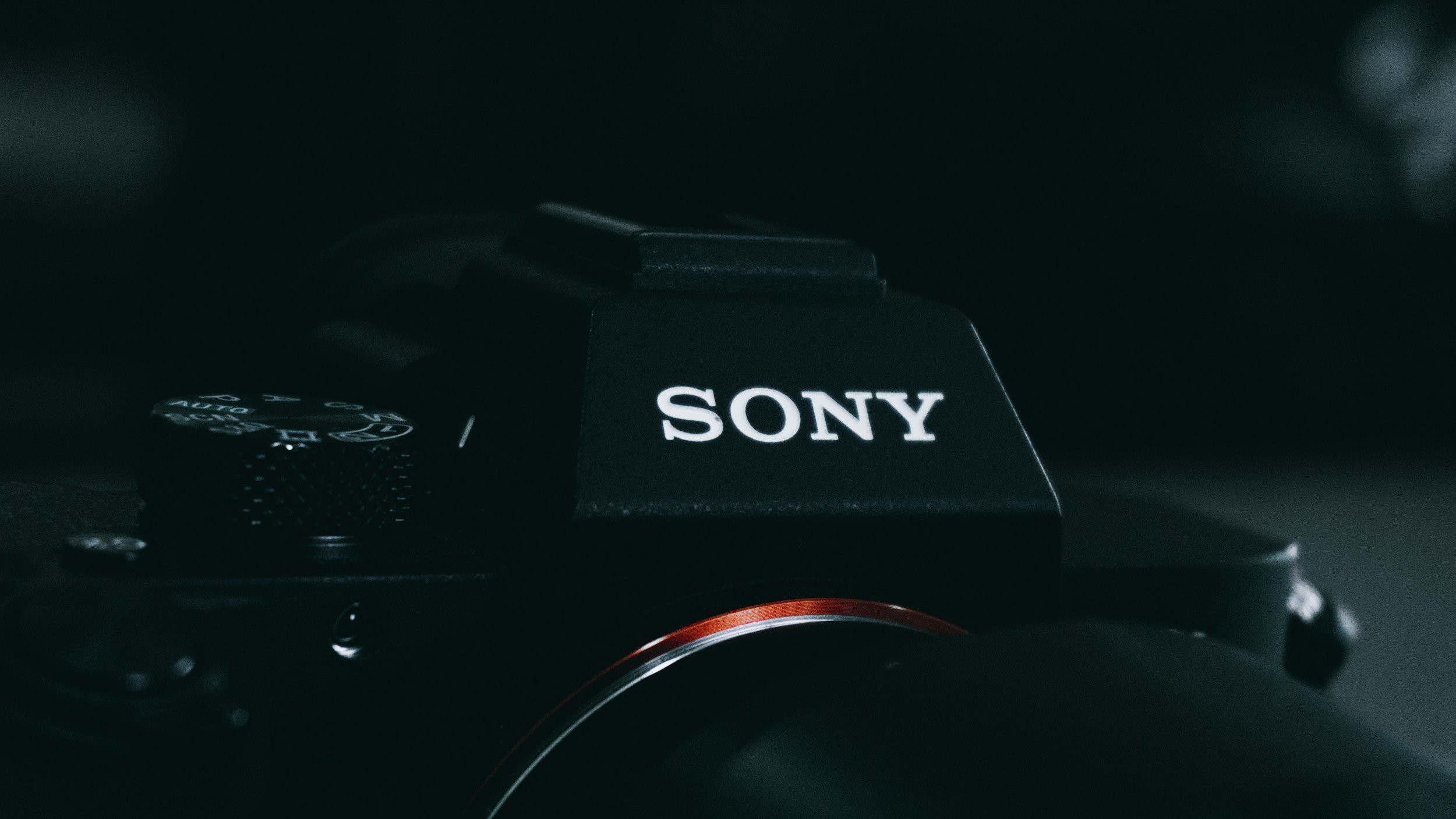 A close-up of a Sony camera, focusing on the top part with the brand name visible, set against a dark background.