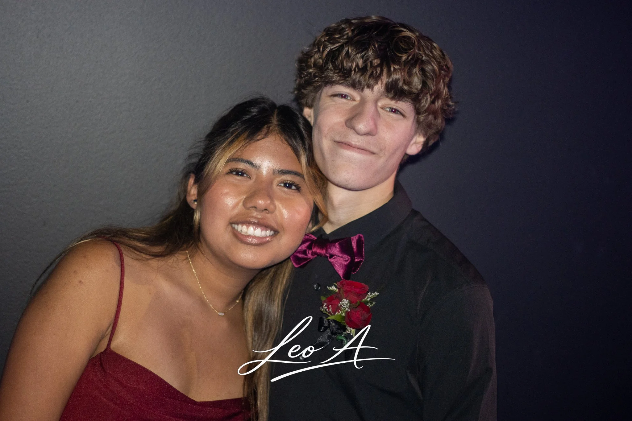 Portrait of a young couple dressed in formal attire at a high school dance, by photographer Leo Assalian.