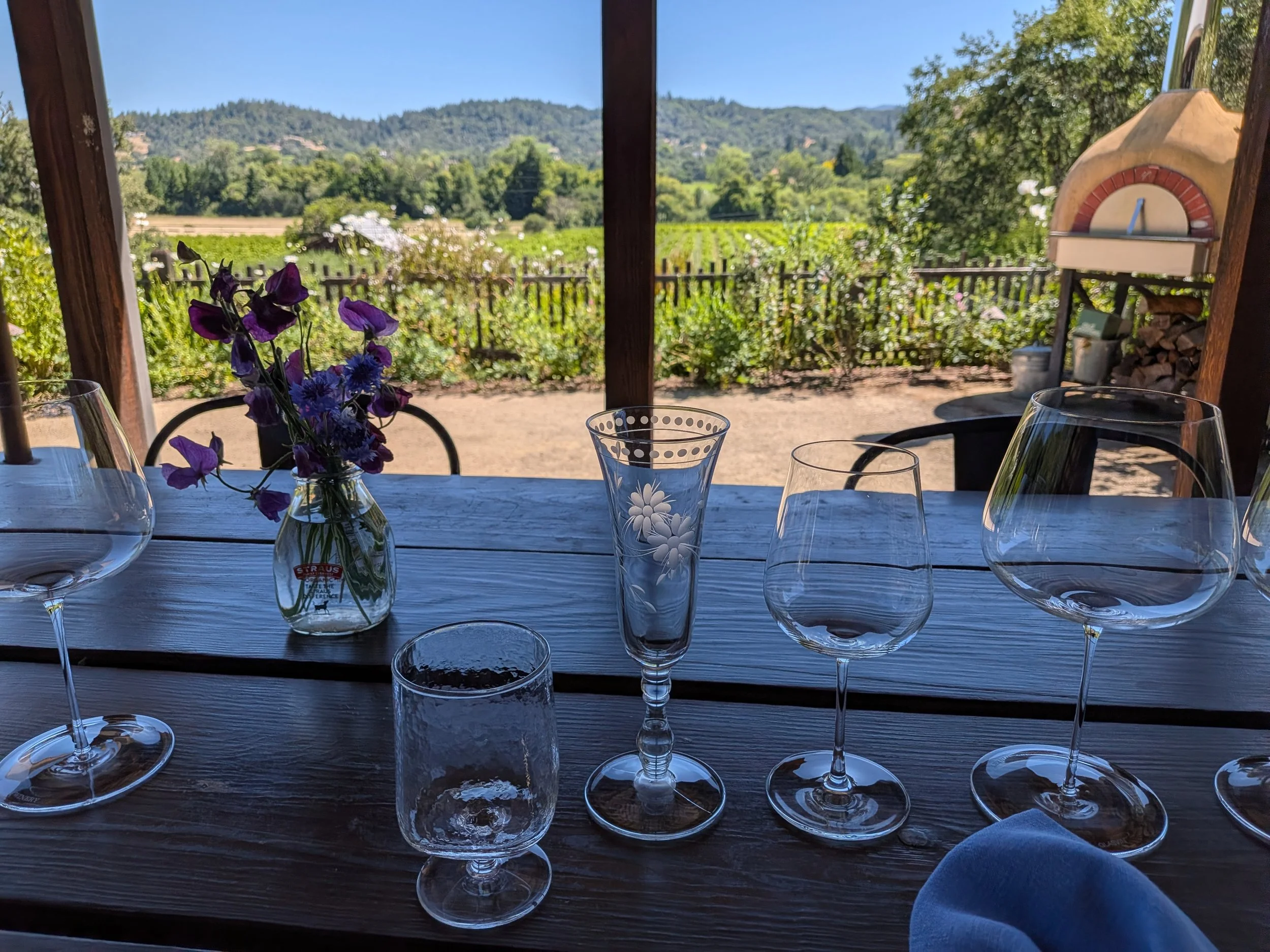 Wine glasses on a table with a vineyard in the background at Capo Creek Winery