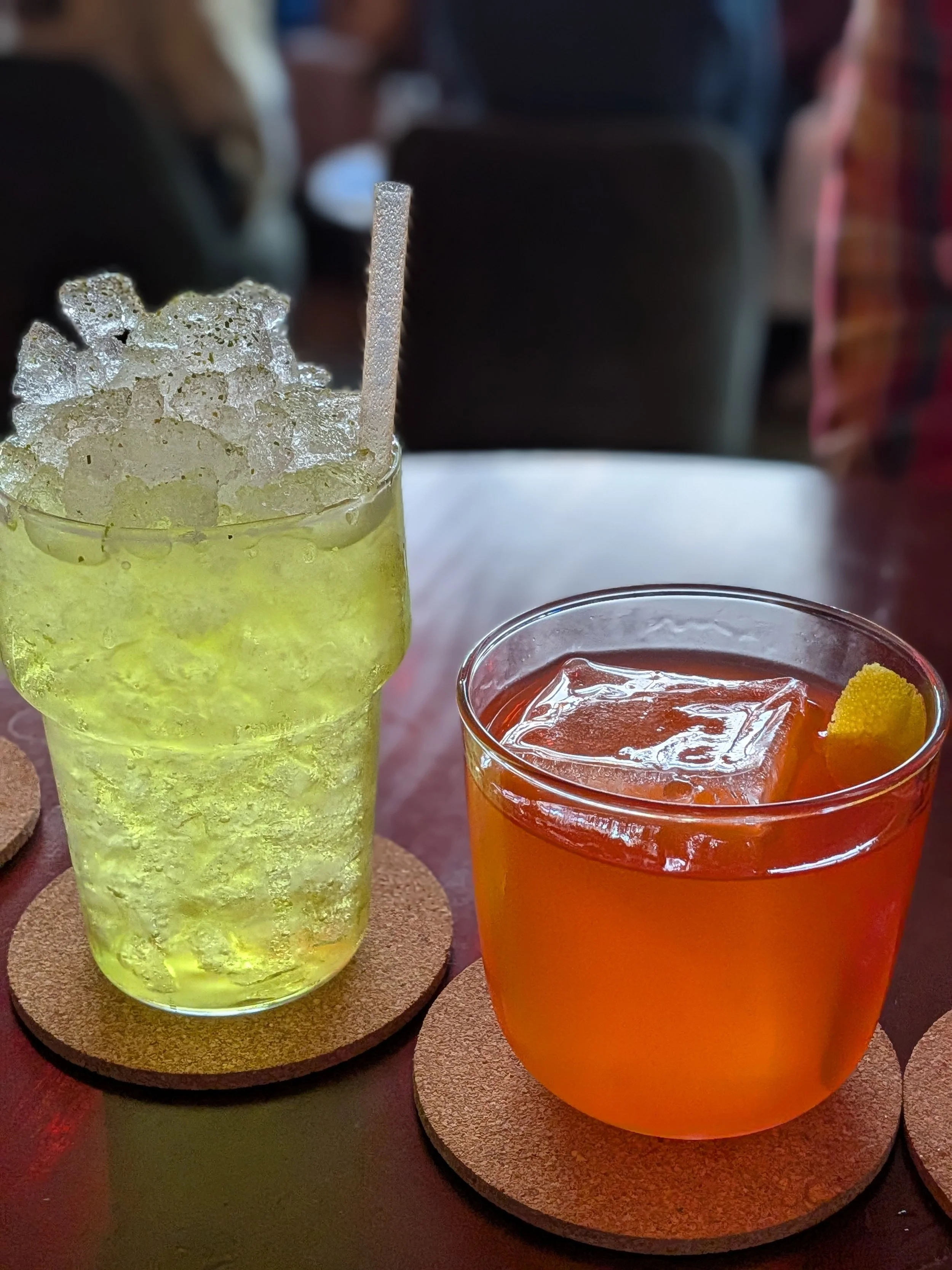 A green and red cocktail on a bar at Jade Jaguar in Kansas City