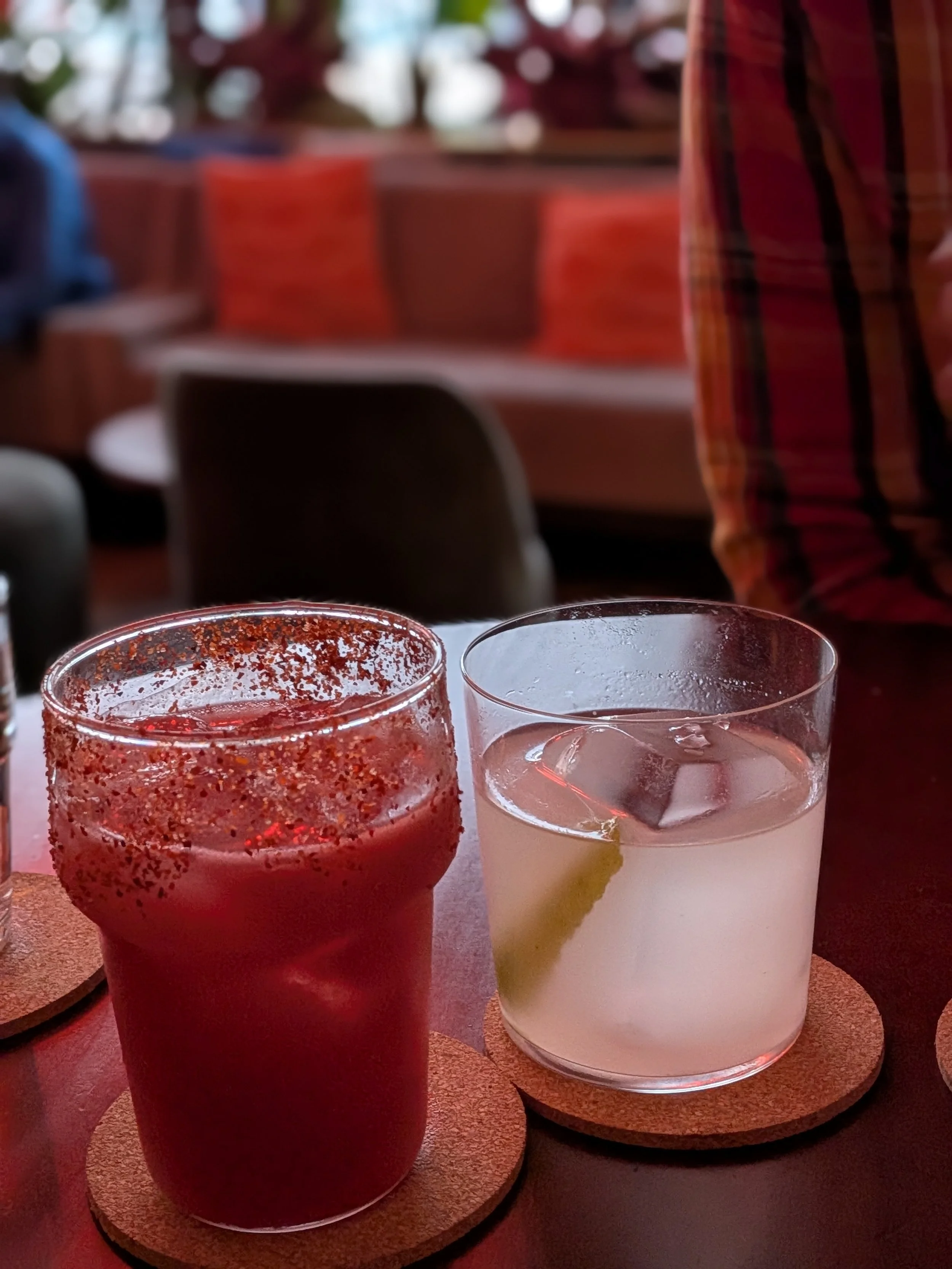 A red and clear cocktail sitting on a table at Jade Jaguar in Kansas City