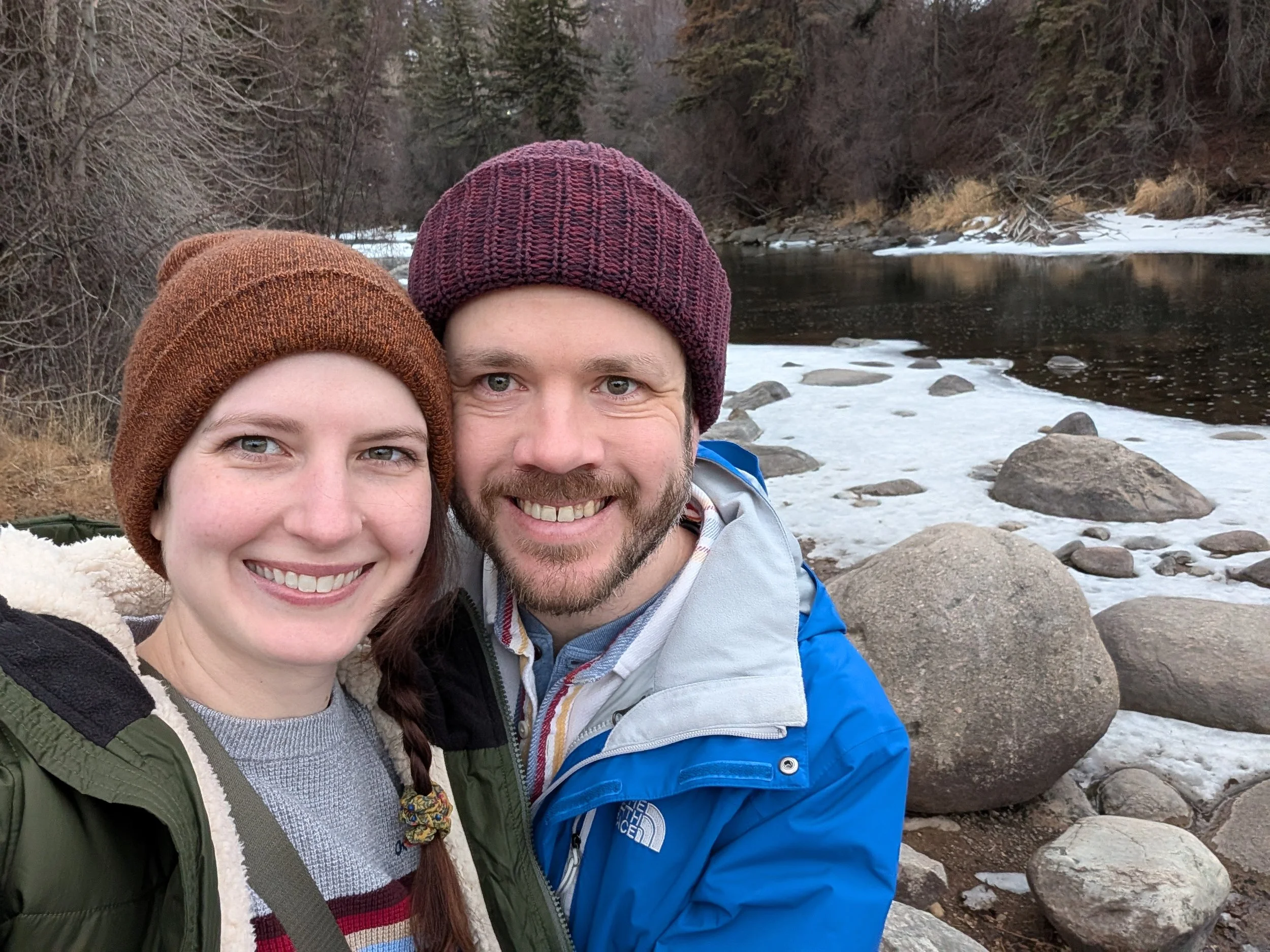 A man and a woman next to a snow covered river outside the Westin Riverfront in Avon, CO.
