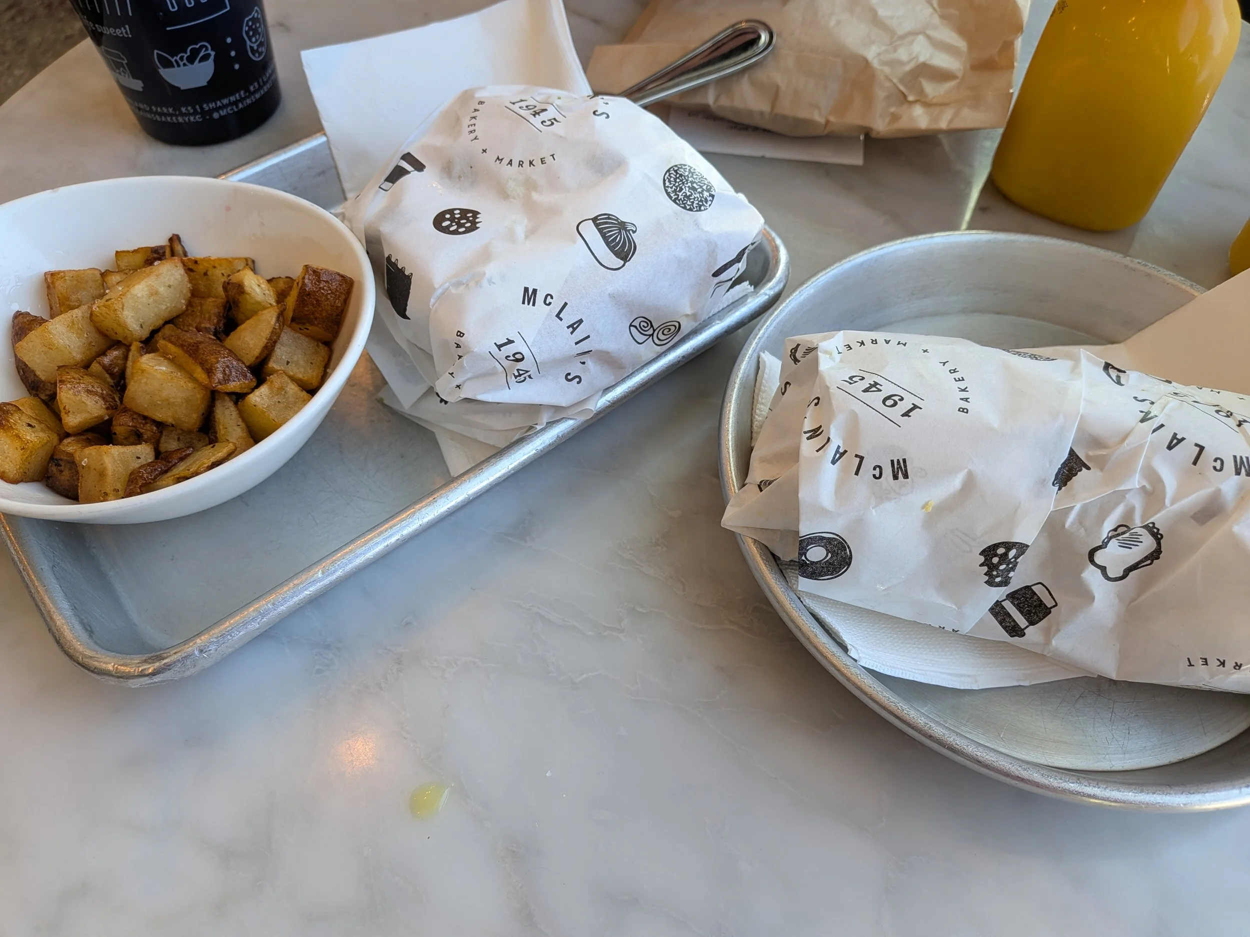 Wrapped breakfast burrito and breakfast sandwich with a side of potatoes from McClain's Market