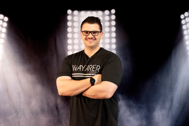 Dylan McElfresh with black Wayfarer CrossFit shirt on a smoke lights background. 