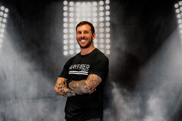 Nate Kozma with black Wayfarer CrossFit shirt on a smoke lights background. 
