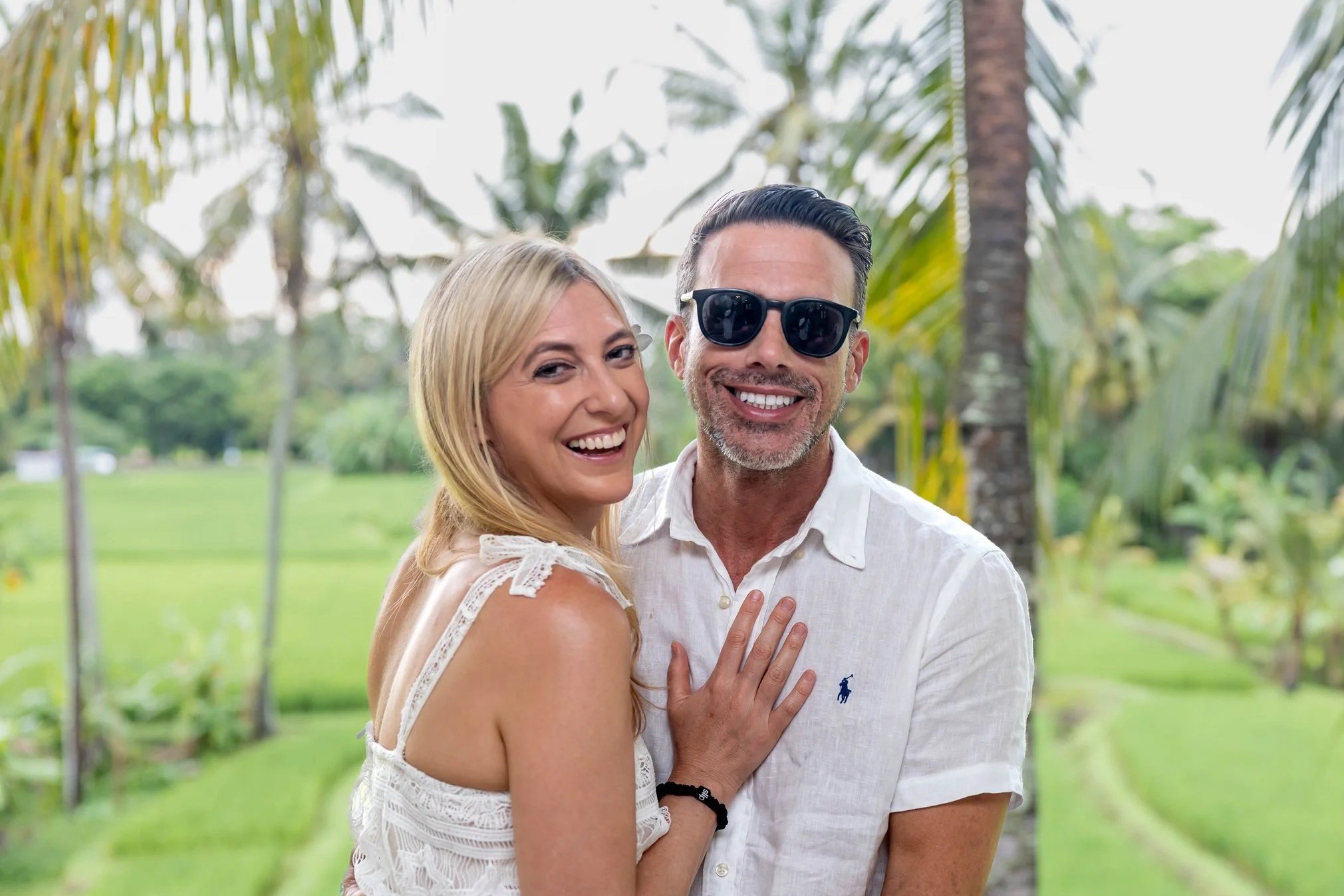 Laurie’s customers, Mariana and Carmen holding hands on a green lawn on their wedding day.