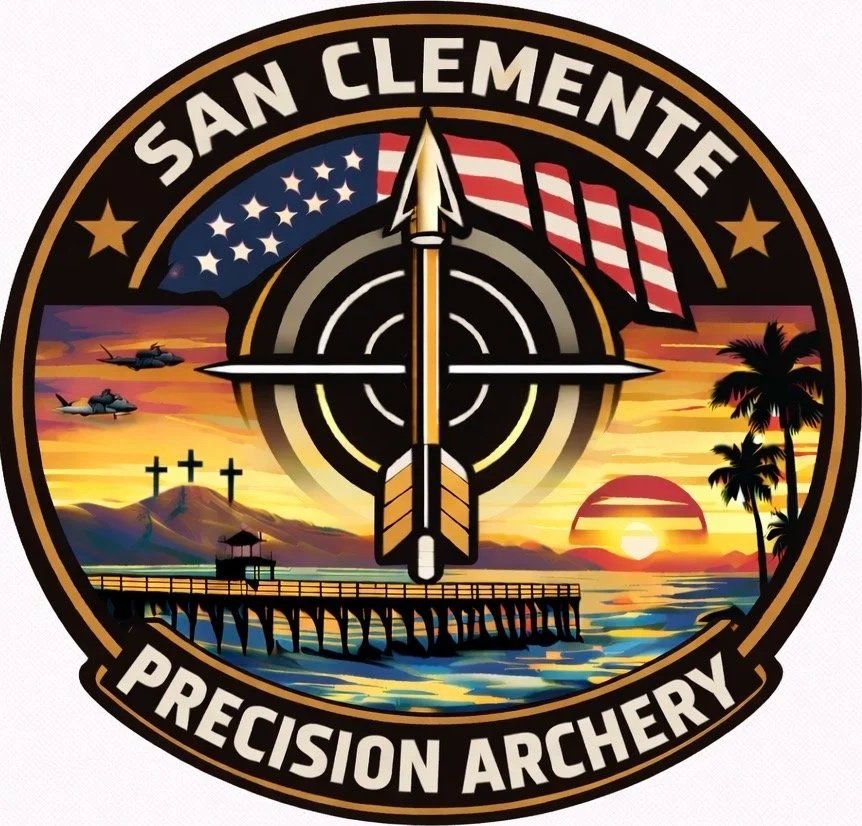 A circular emblem with the text 'San Clemente Precision Archery' around the border. Inside, a large arrow points upward, over a target crosshair, with the American flag and a sunset over water. The scene includes a pier, three crosses on a hill, three fighter jets flying, and palm trees.