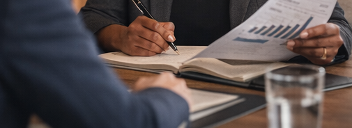 People in a business meeting reviewing documents and graphs