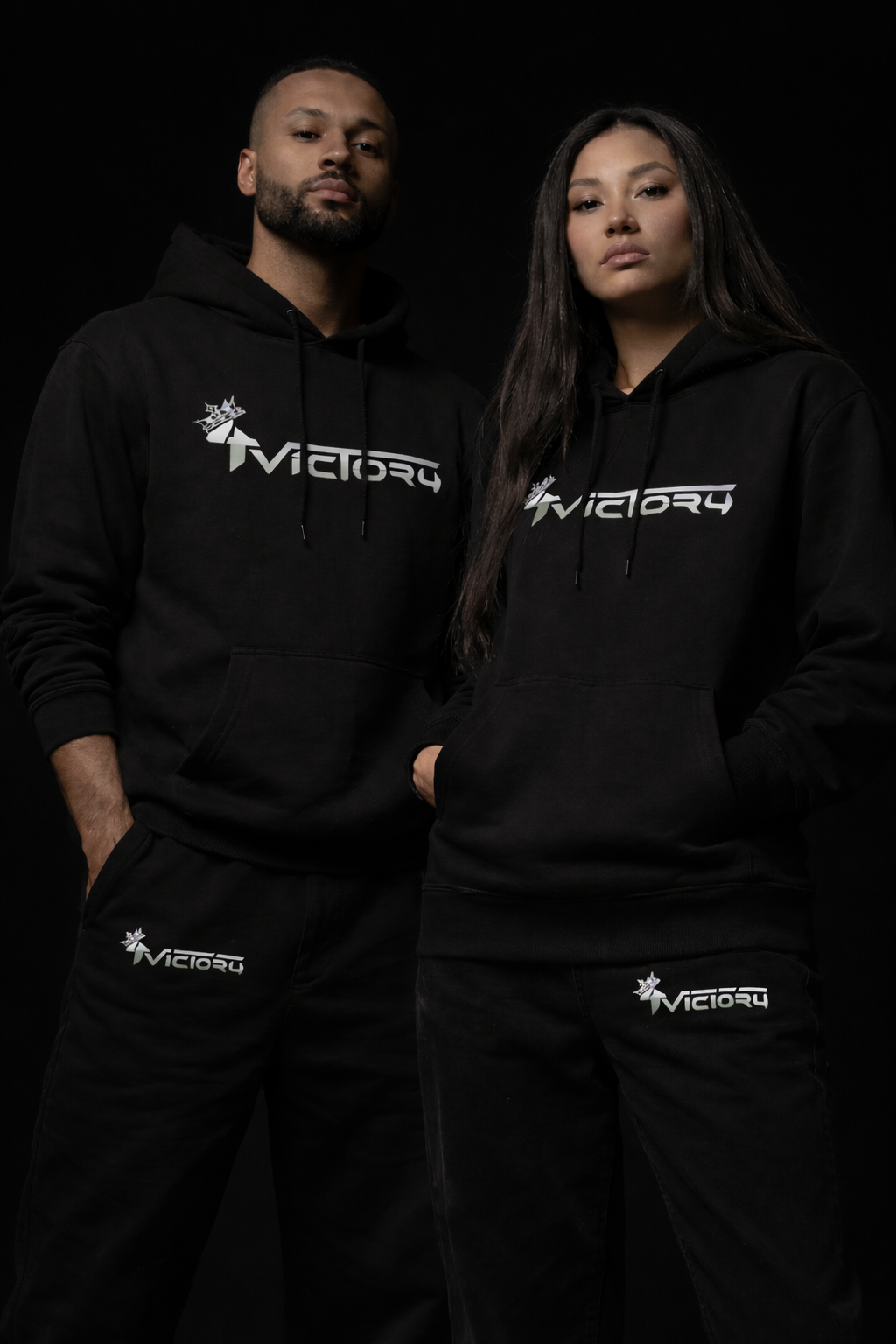Deux personnes portant des sweats à capuche noirs avec le logo '4Victory' blanc et vert, posant contre fond noir.