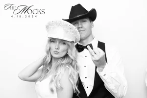 A man and woman dressed in formal attire posing for a photo, with the man wearing a cowboy hat and bow tie, and the woman wearing a hat with veil, against a white background. Text on the image reads